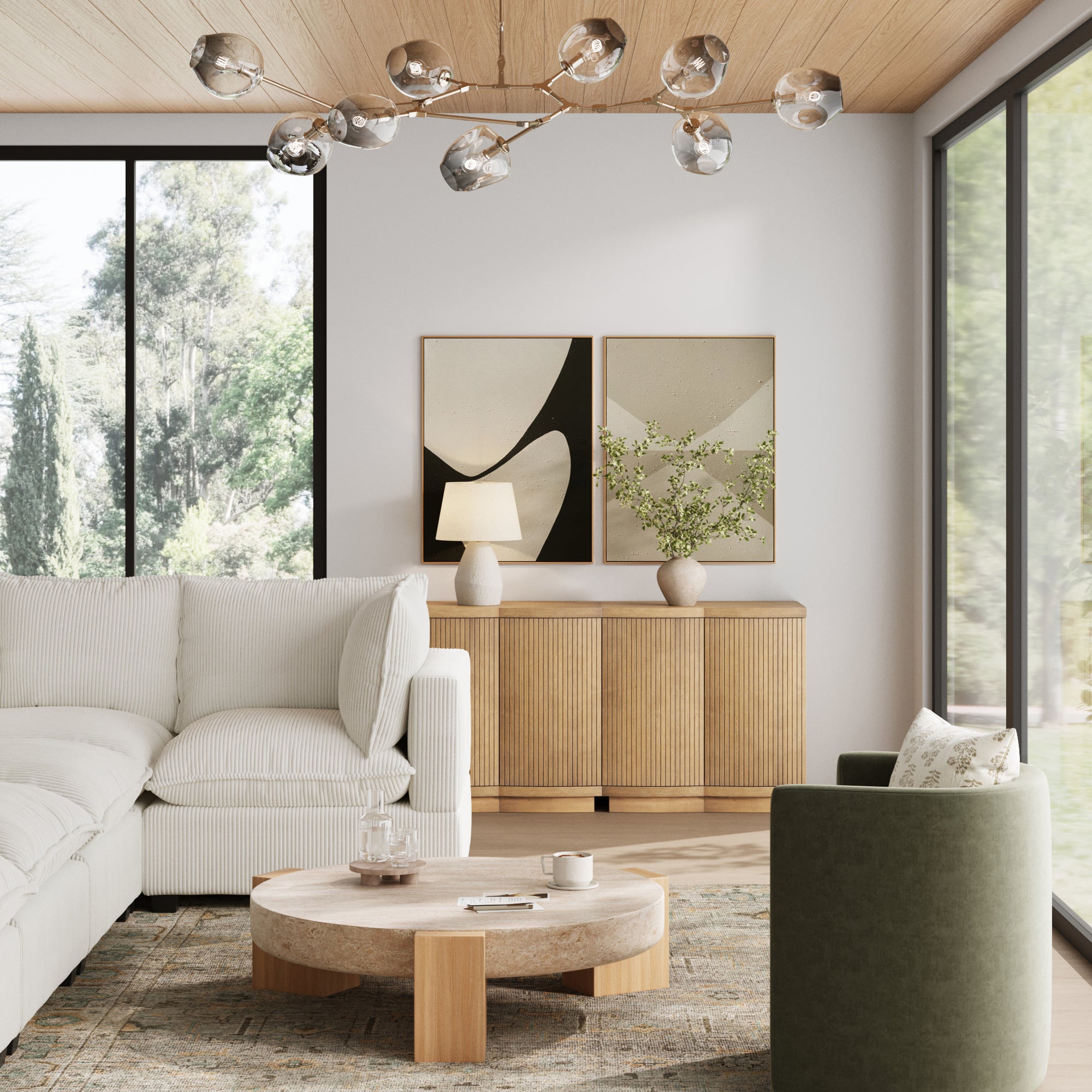 A modern living room with a white sectional, beige round coffee table, green armchair, Nathan James Mid-Century Modern Fluted Console (set of 2), abstract art, lamp, and vase. Large windows reveal trees for a true mid-century vibe.