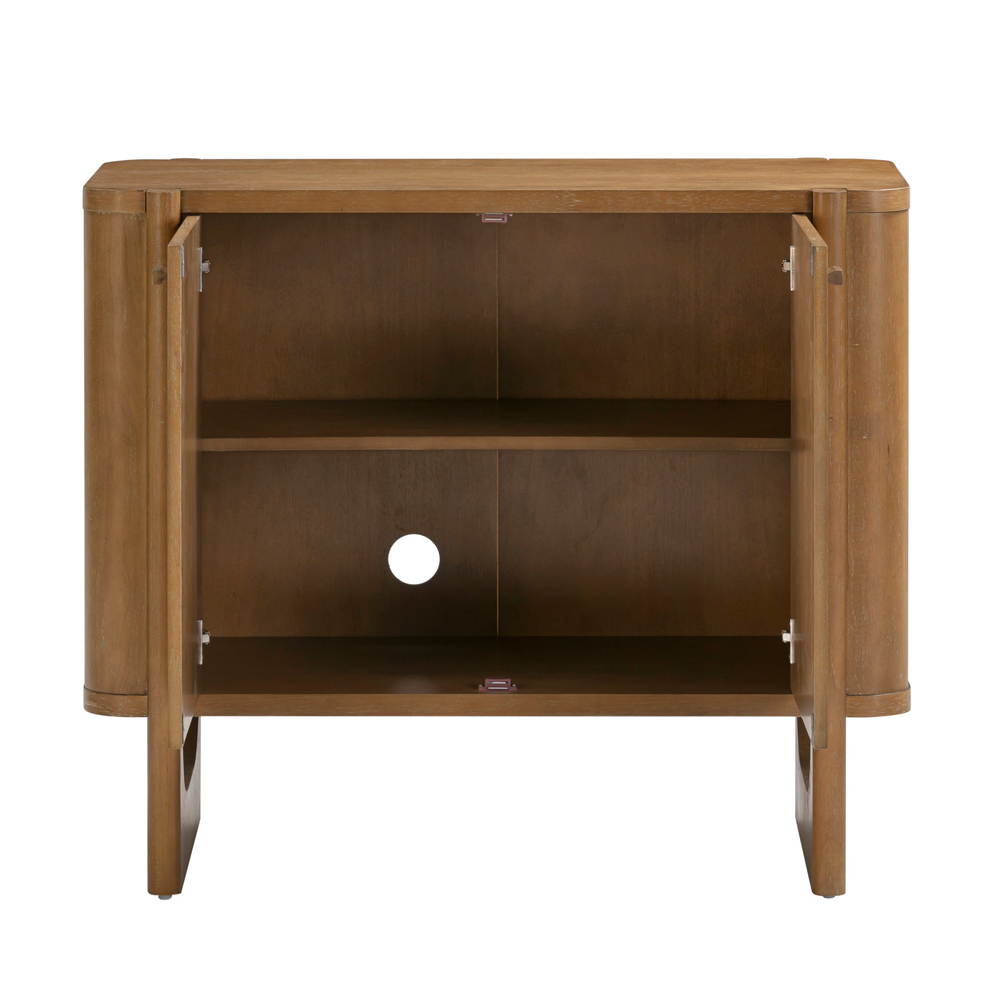 A wooden cabinet with two open doors, showing an interior shelf and a circular cutout in the back panel, designed for cable management. The cabinet has a natural brown finish and simple, modern lines.