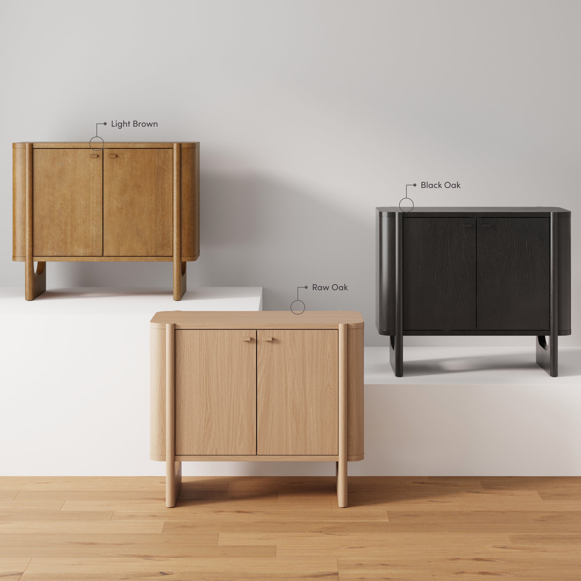 Three wooden cabinets in different finishes—light brown, black oak, and raw oak—are displayed against a white background on staggered platforms, highlighting their color and wood grain variations.