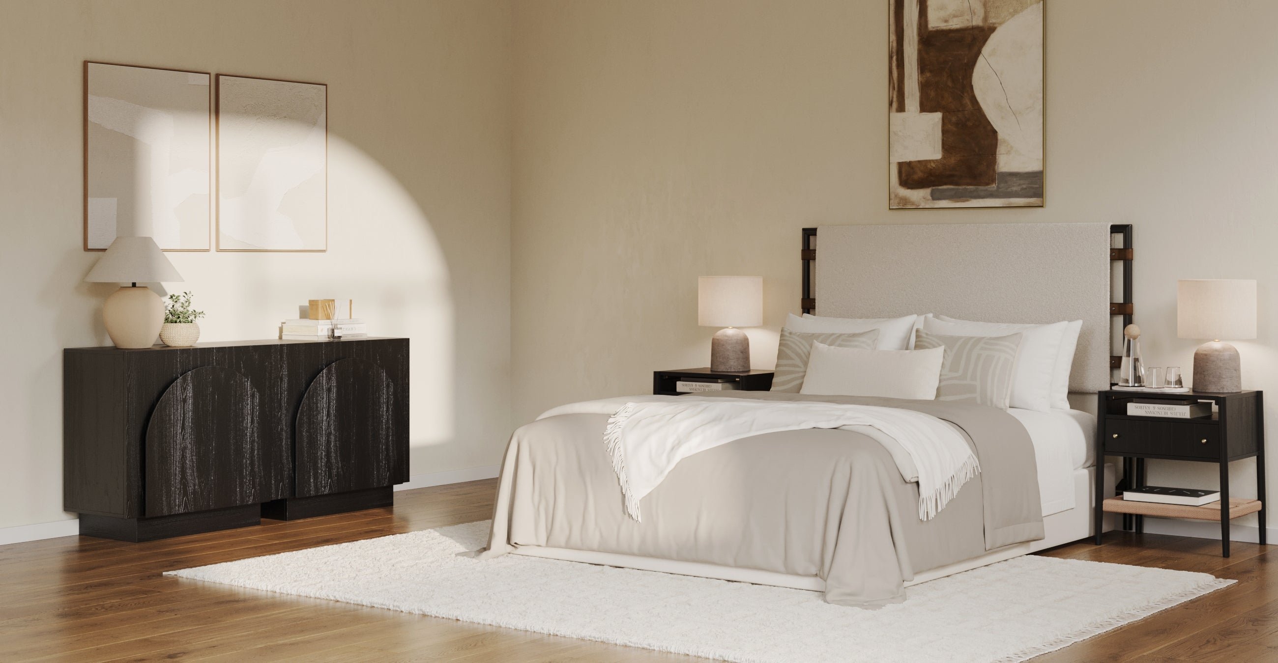 A modern, minimalist bedroom with a large bed, white bedding, two bedside tables with lamps, a black dresser, abstract artwork on the walls, and a white rug on wooden floors. Sunlight streams in from the left.