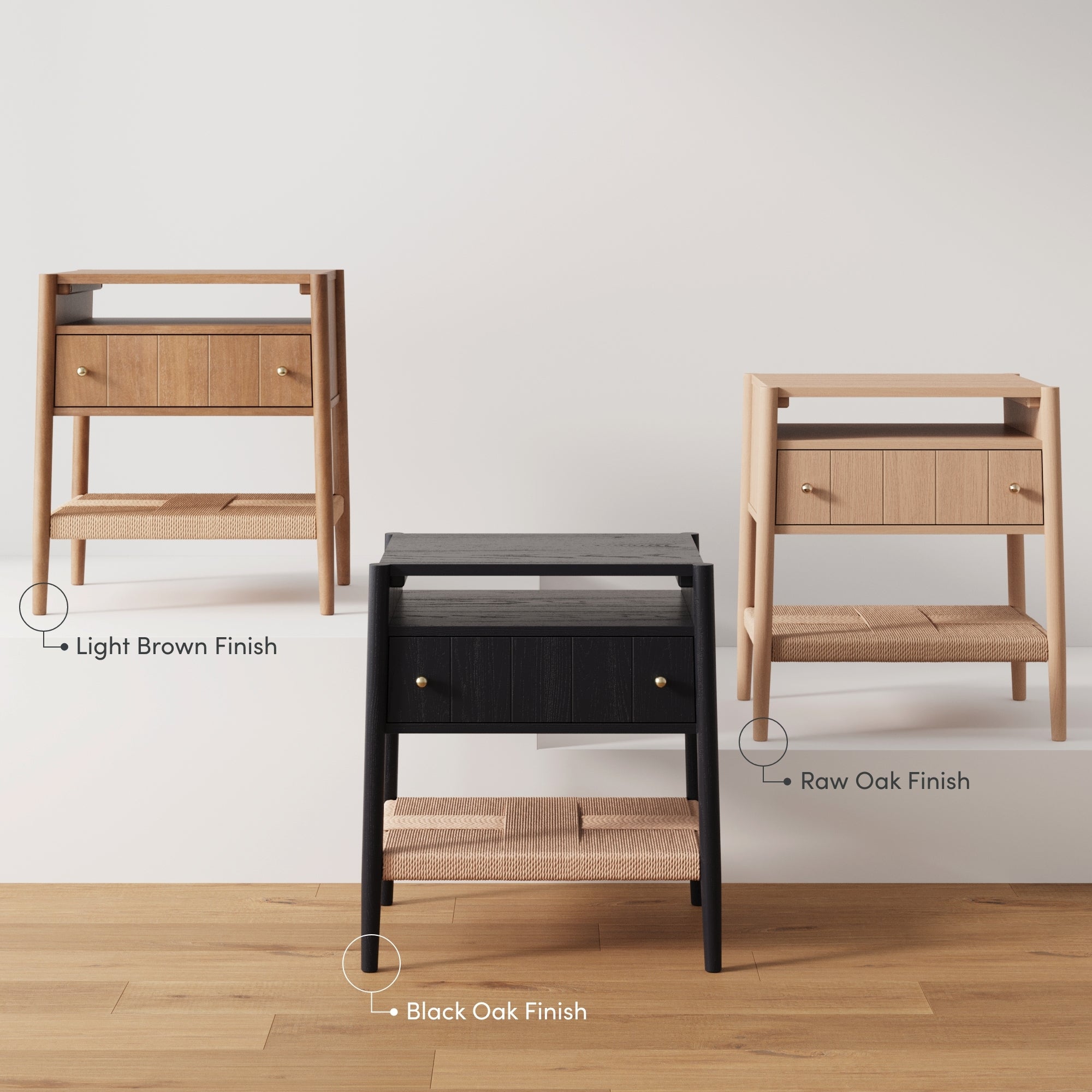 Three nightstands with two drawers and a woven shelf, shown in light brown finish, black oak finish, and raw oak finish, displayed side by side on a wooden floor against a white wall.