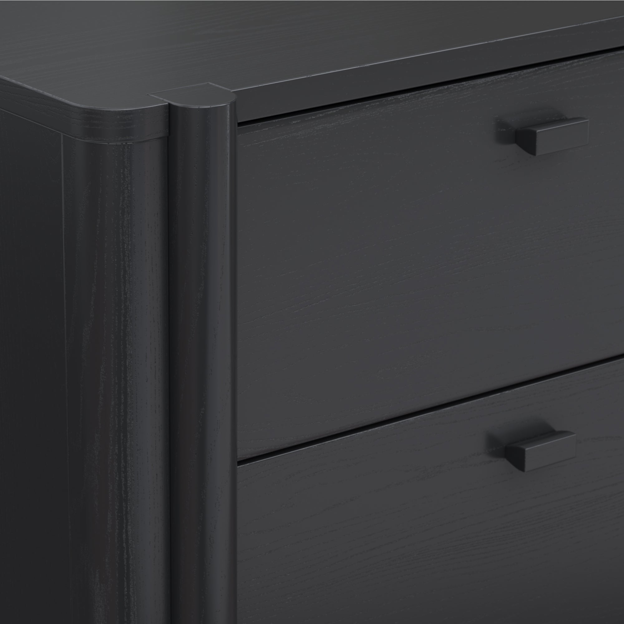 Close-up of a modern, dark-colored wooden dresser with two visible drawers, each featuring a small, square black handle. The dresser has a smooth finish and slightly rounded edges on the corner.