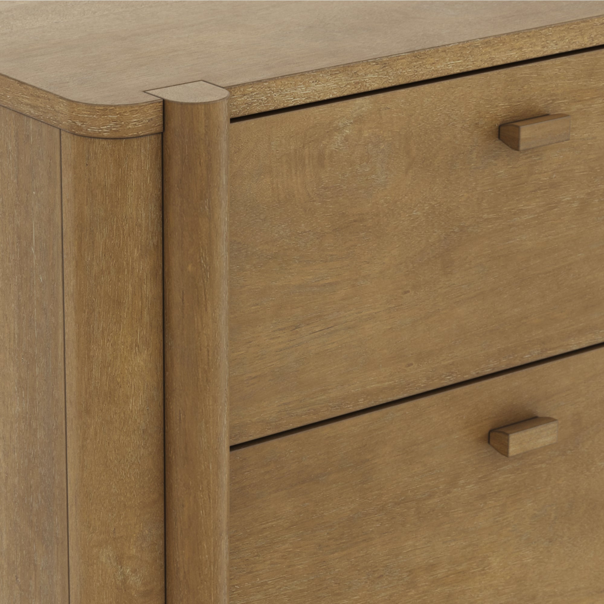 Close-up view of a wooden dresser with a light brown finish, showing two drawers with simple rectangular handles and rounded edges on the corner of the furniture.