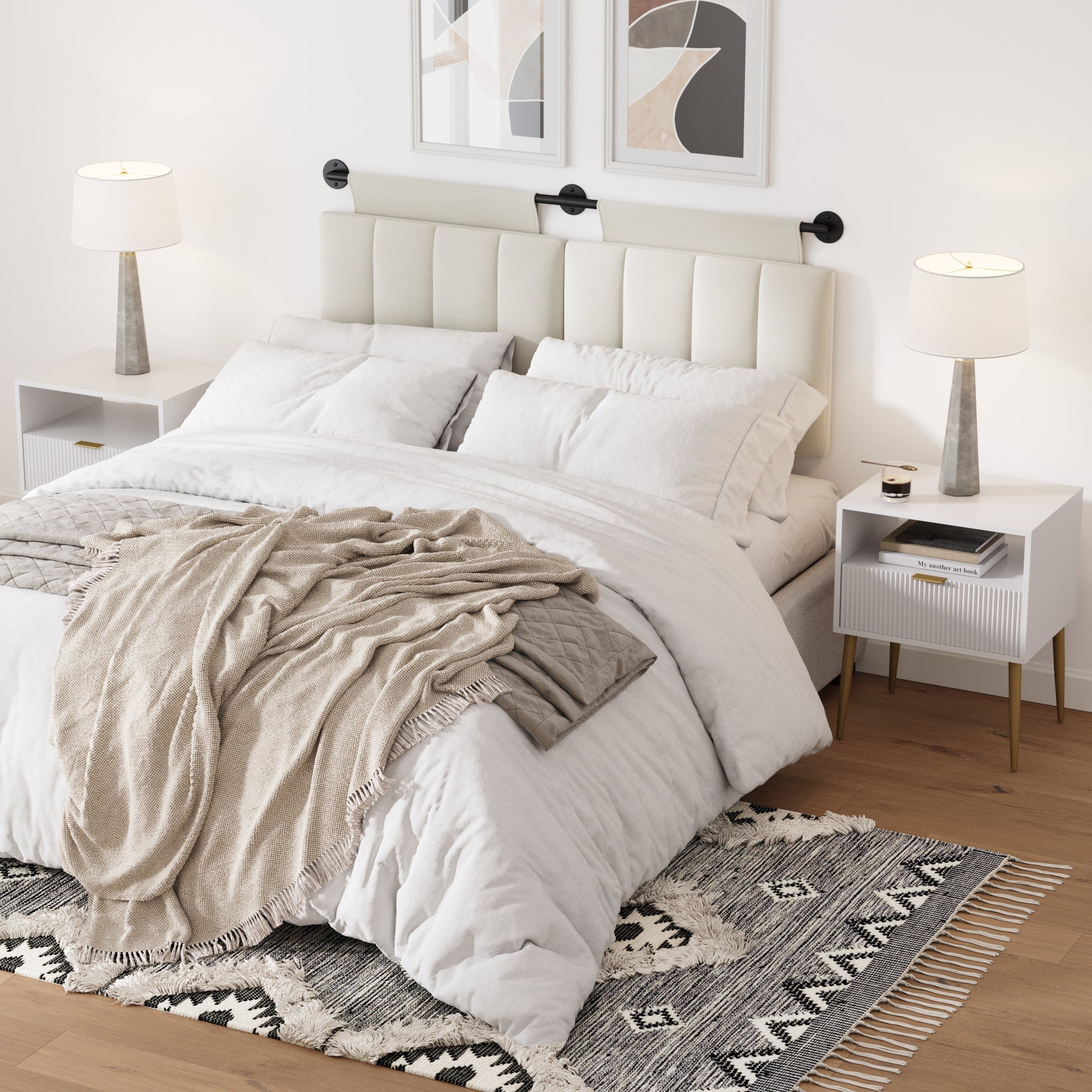 A modern bedroom with a neatly made bed, white bedding, beige throw, and two Nathan James Mid-Century Fluted Nightstands with lamps. Framed abstract art hangs above the headboard, complemented by a patterned rug on wood floors.