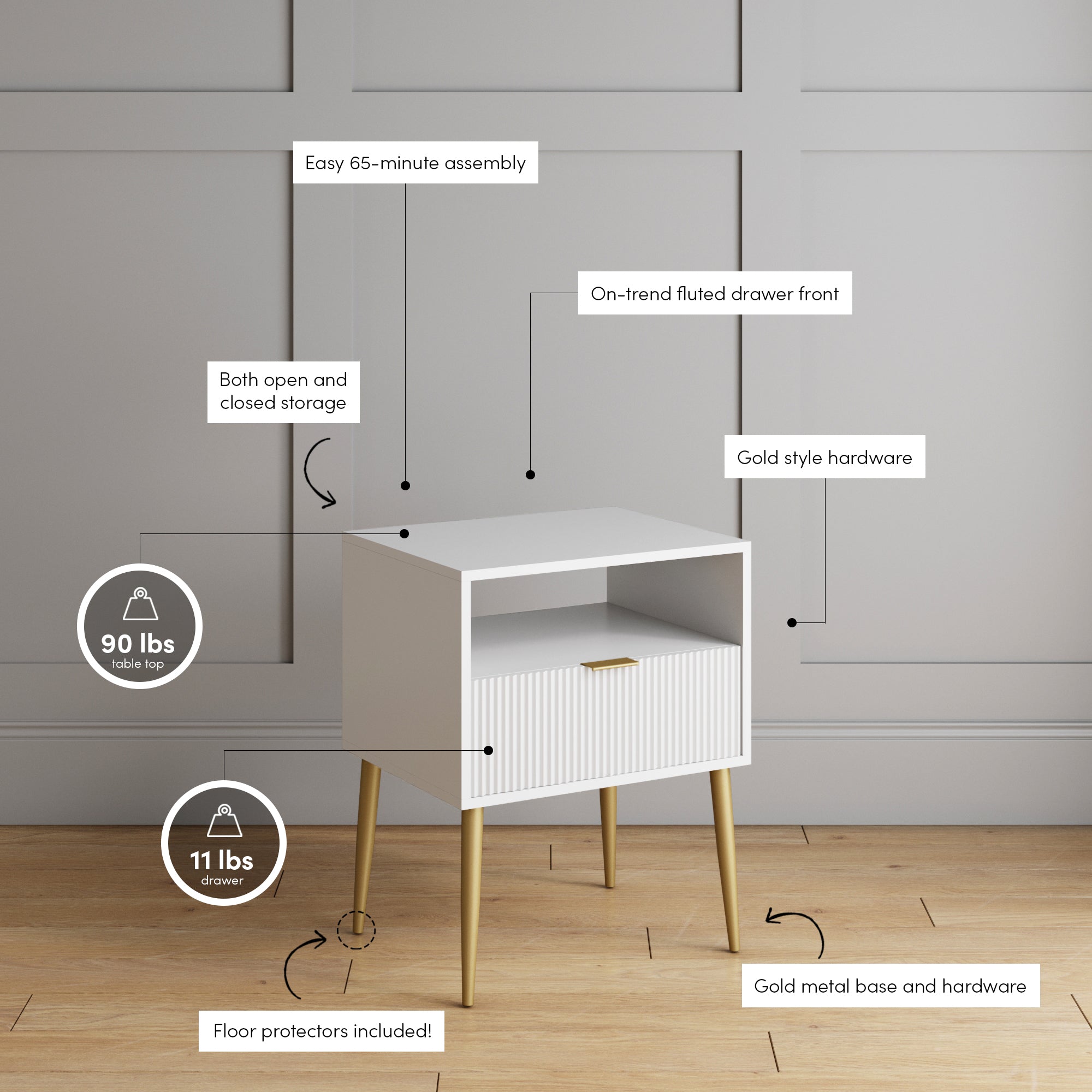 A small white side table with gold legs stands against a gray paneled wall. It features an open shelf, a fluted drawer front with gold hardware, and labeled details about its assembly, storage, and weight limits.