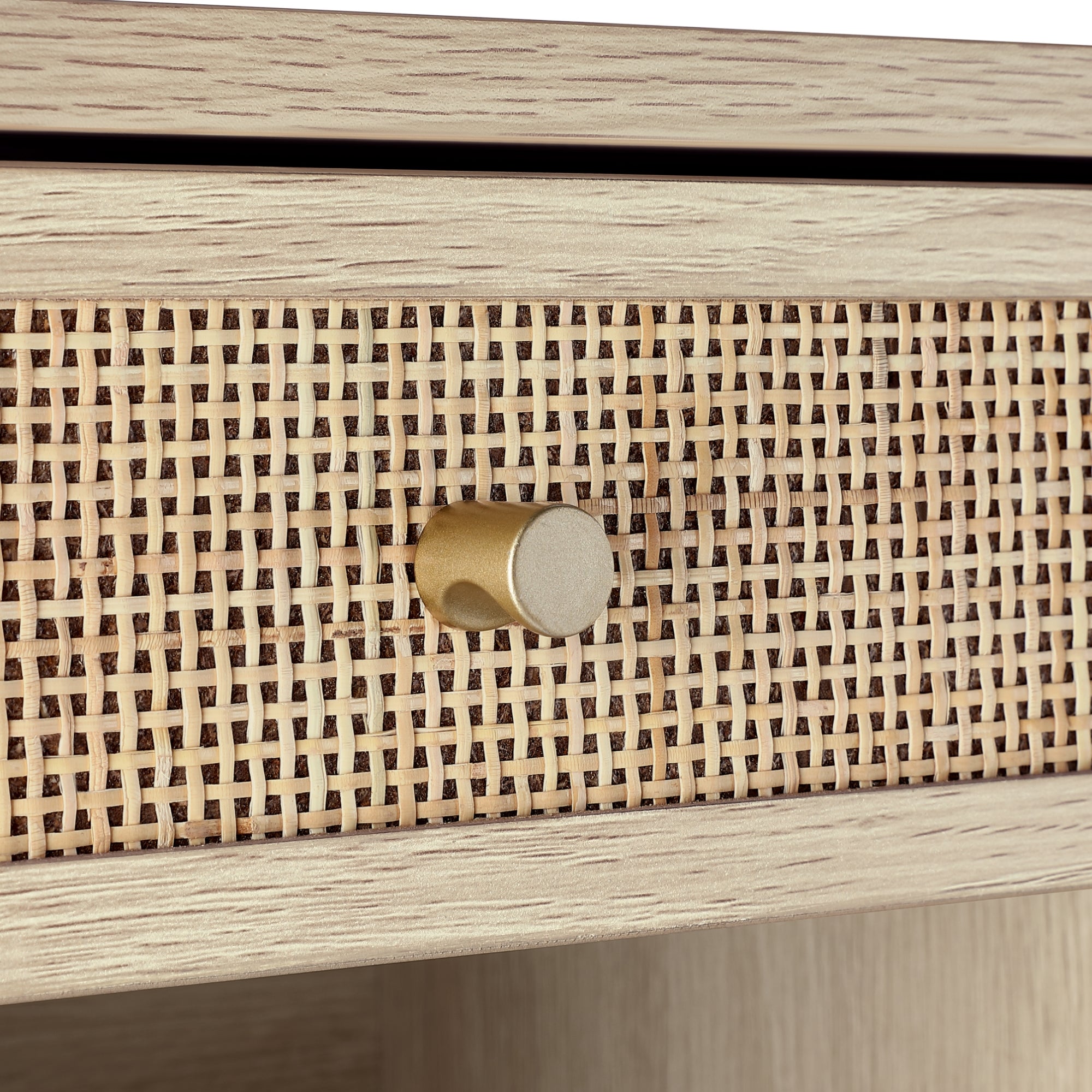 Close-up of a light wood drawer featuring a woven cane front panel and a round, gold-colored knob. The drawer has a natural, textured appearance with a modern, minimalist design.