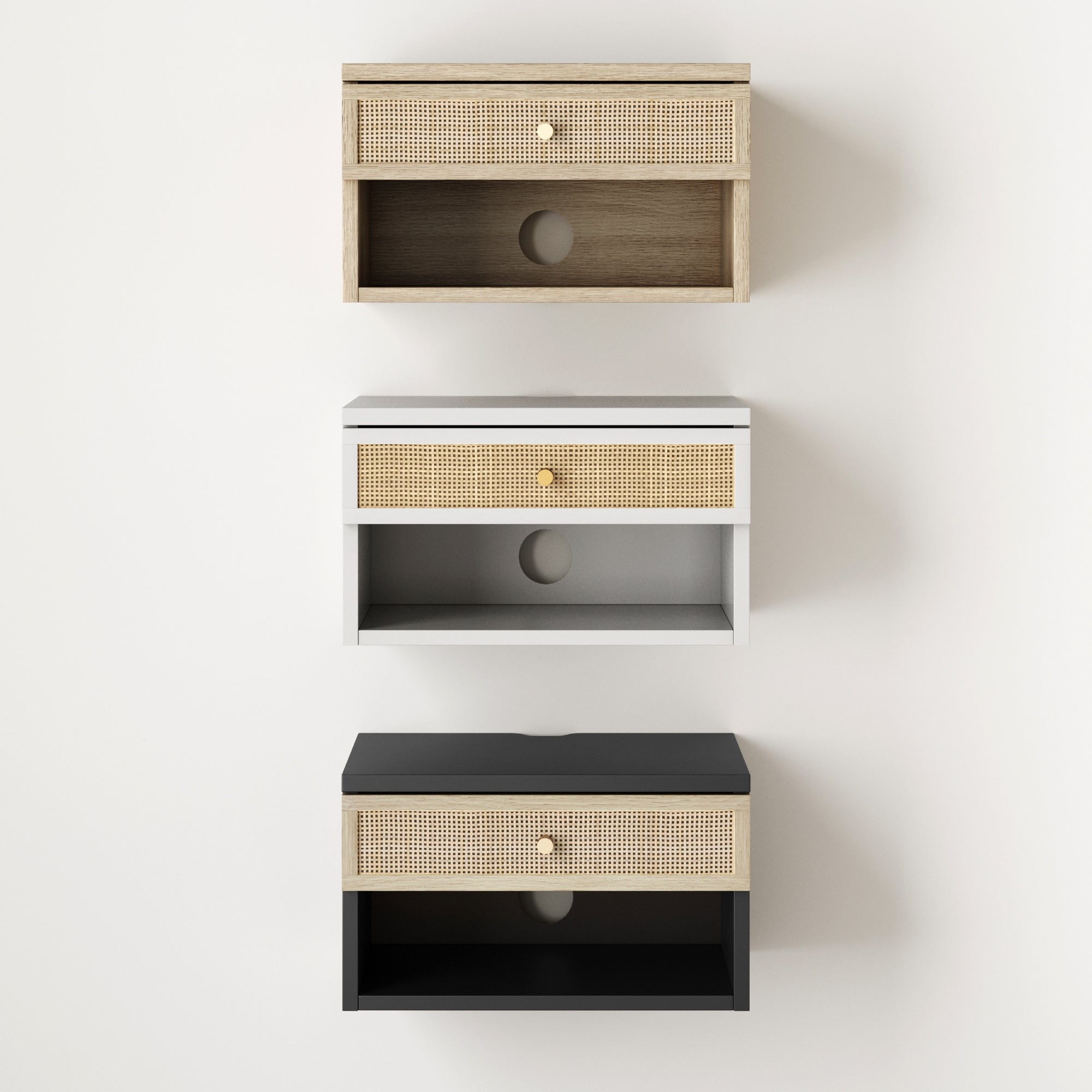 Three wall-mounted floating nightstands in light wood, white, and black finishes, each featuring a rattan drawer front, gold knob, and open shelf with a circular hole at the back for cable management.