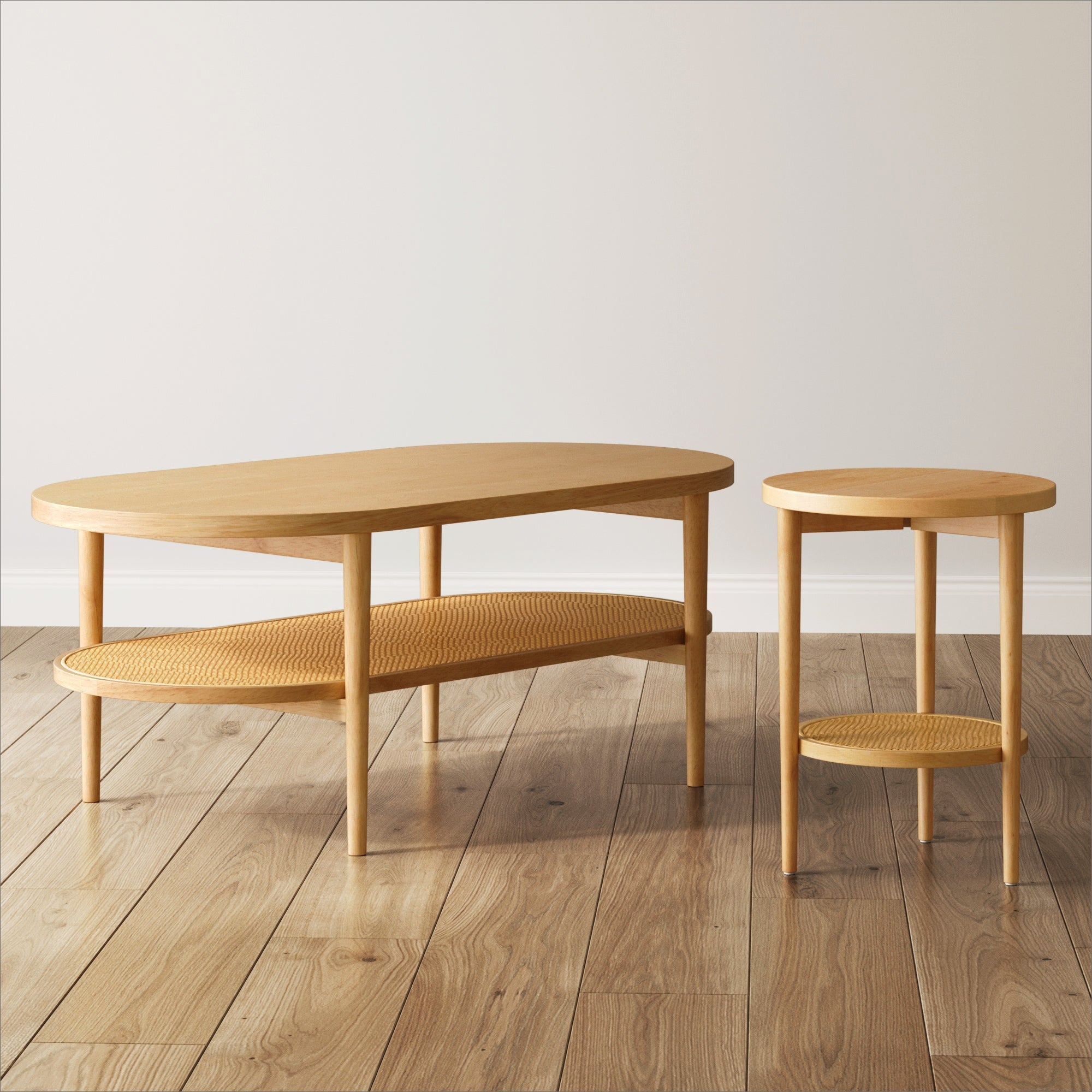 A wooden coffee table and matching side table with rounded edges and lower woven shelves, placed on a light wood floor against a plain white wall.