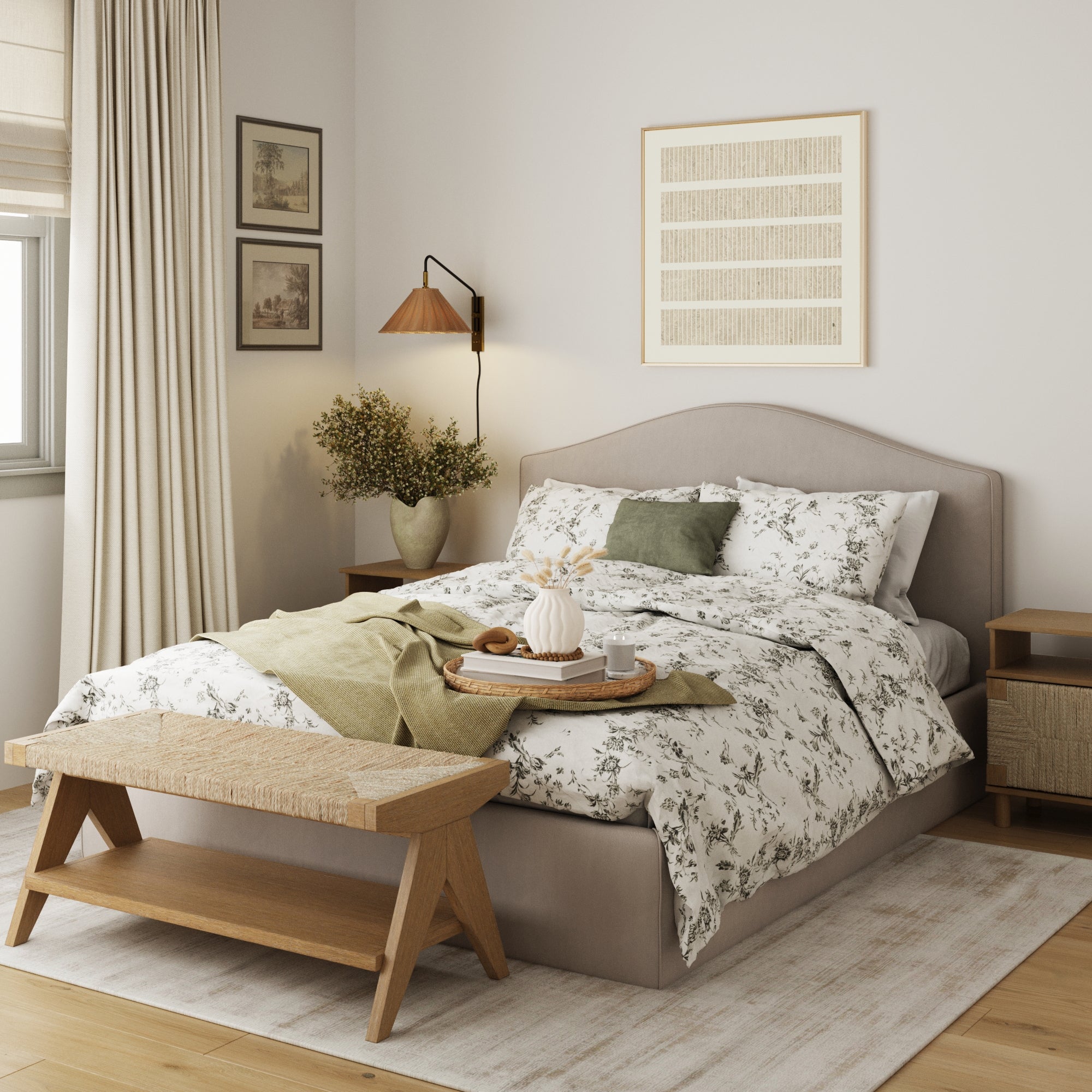 A cozy bedroom with a double bed featuring floral bedding, green accents, a wooden bench at the foot, a tray with decor on the bed, light-toned curtains, wall art, framed pictures, and a bedside table with a lamp and plant.