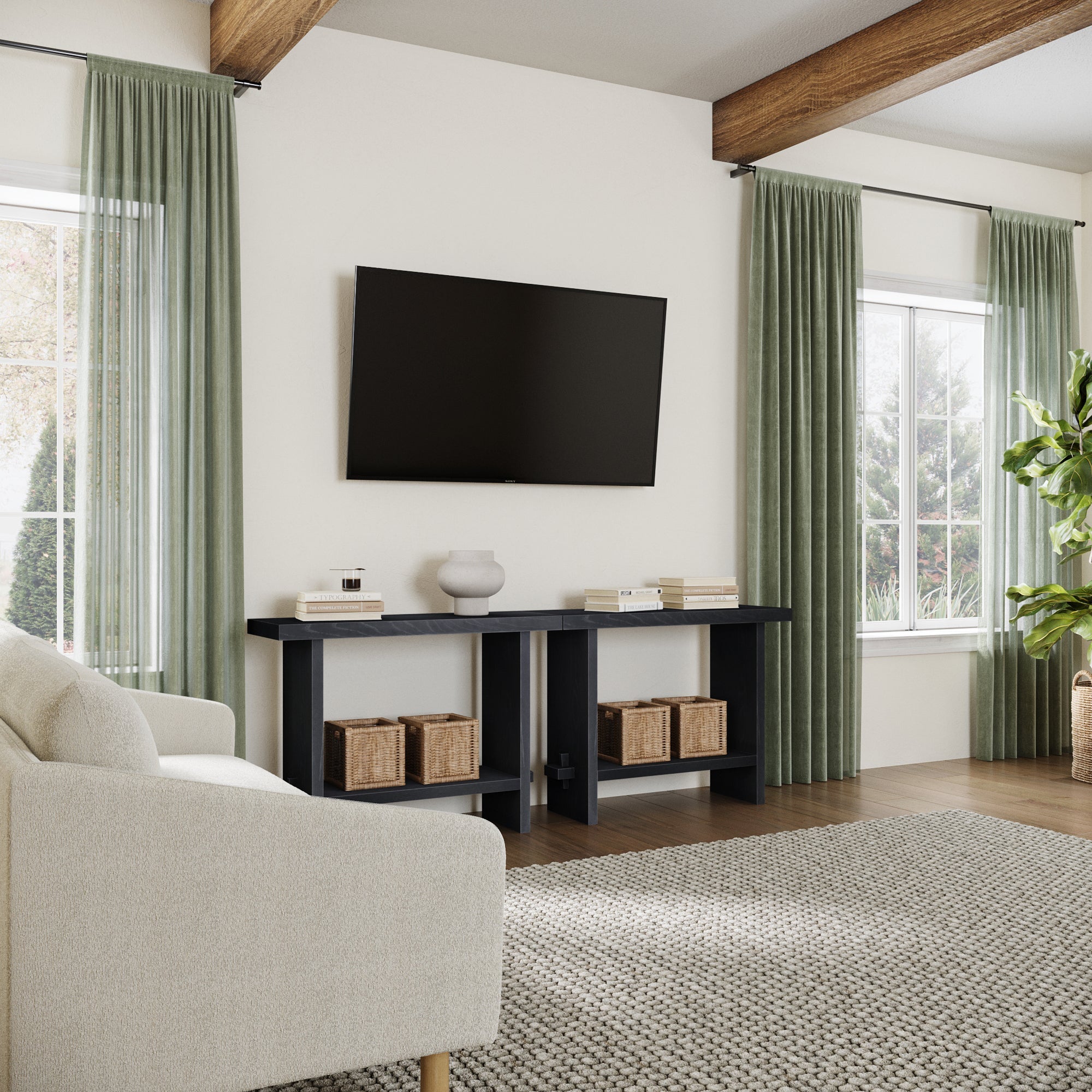 A modern living room with a wall-mounted TV, Nathan James Wood Console Tables Black Oak (Set of 2) with baskets and decor, a light sofa, green curtains, large windows, wooden beams, and a textured rug.