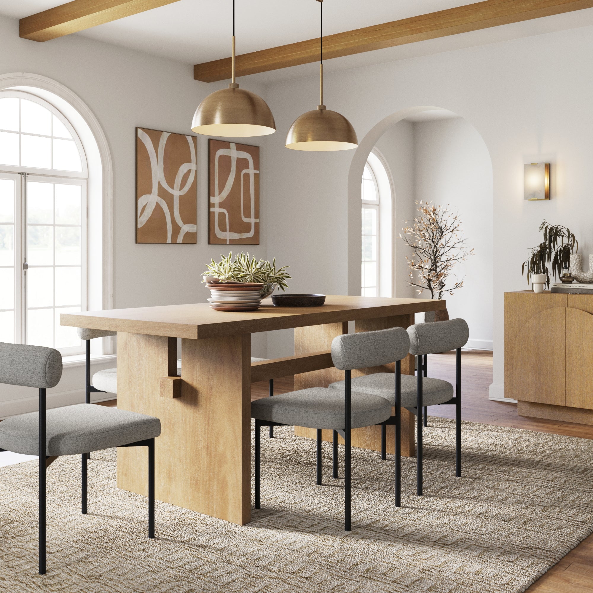 A modern dining room features the Nathan James Mid-Century Dining Set in Feather Gray with 6 cushioned chairs, gold pendant lights, abstract art, arched windows, and a textured rug. Plants and decor accents complete the bright, inviting space.
