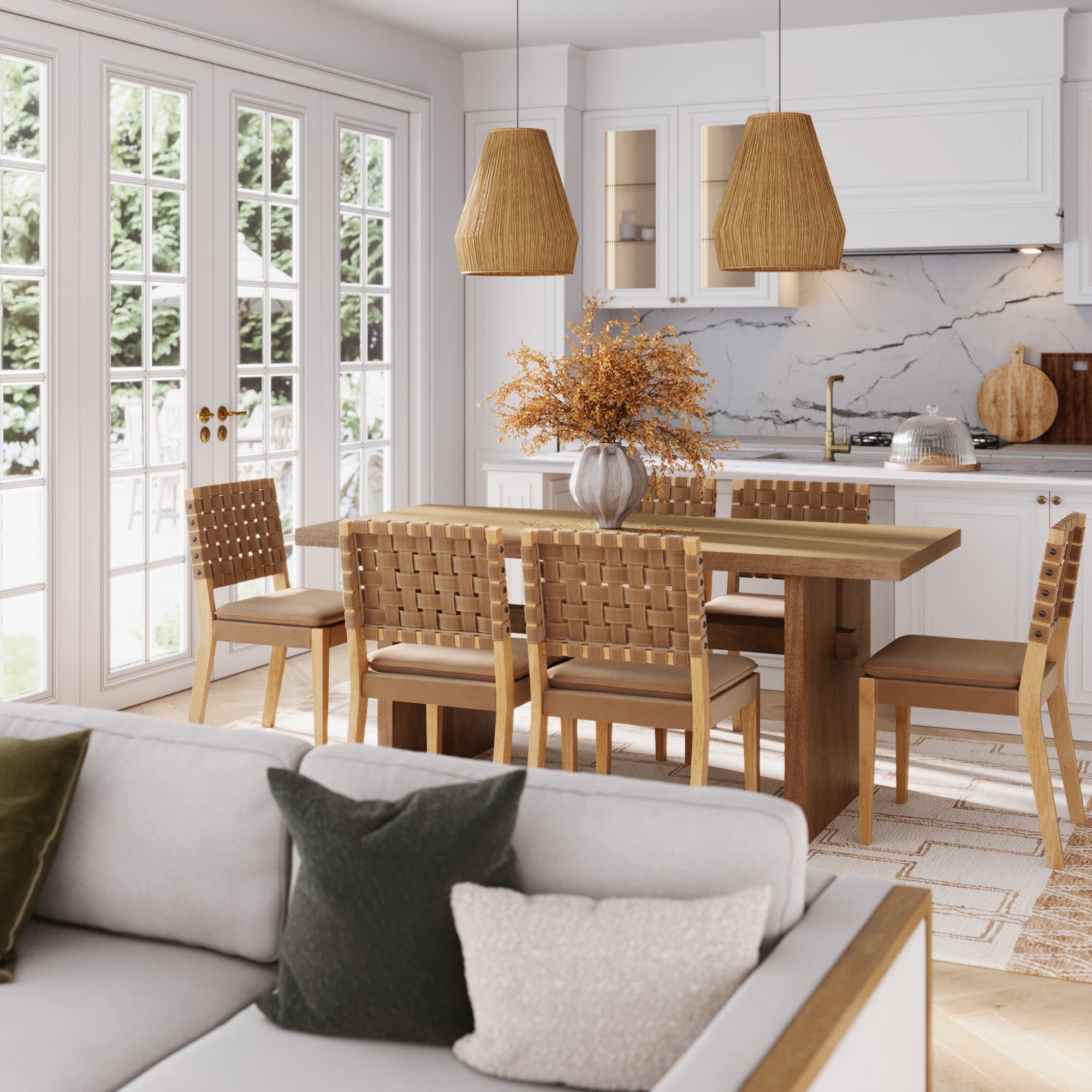 A bright, modern kitchen and dining area features the Nathan James Mid-Century Woven Dining Set in light brown with 6 chairs, pendant lights, a vase with dried branches, large windows, and a light gray sofa with throw pillows in the foreground.