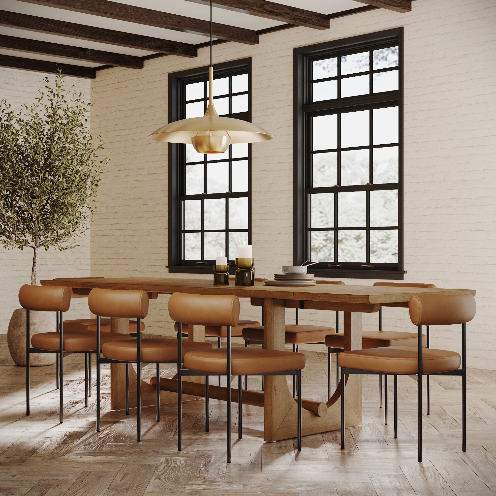 A modern dining room featuring the Nathan James Extendable Dining Table Set with 8 faux leather chairs, accented by a potted tree, candle decor, and large windows that bathe the space in natural light.