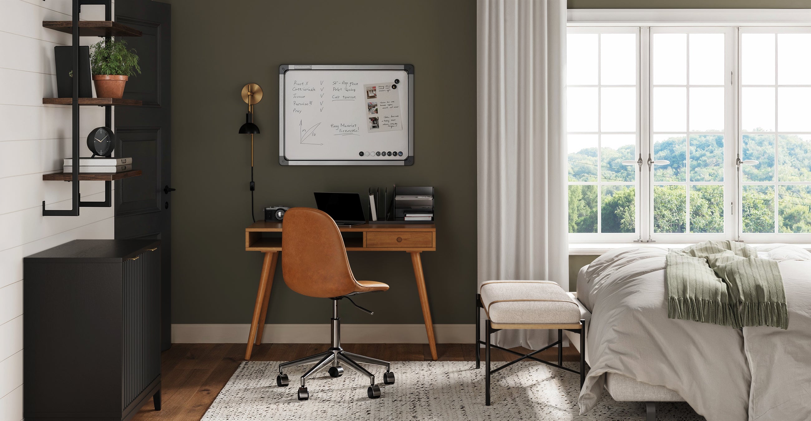 A cozy home office setup in a bedroom with a wooden desk, brown chair, whiteboard, black cabinet, shelves with plants, large windows with white curtains, and a bed with white bedding next to a small bench.