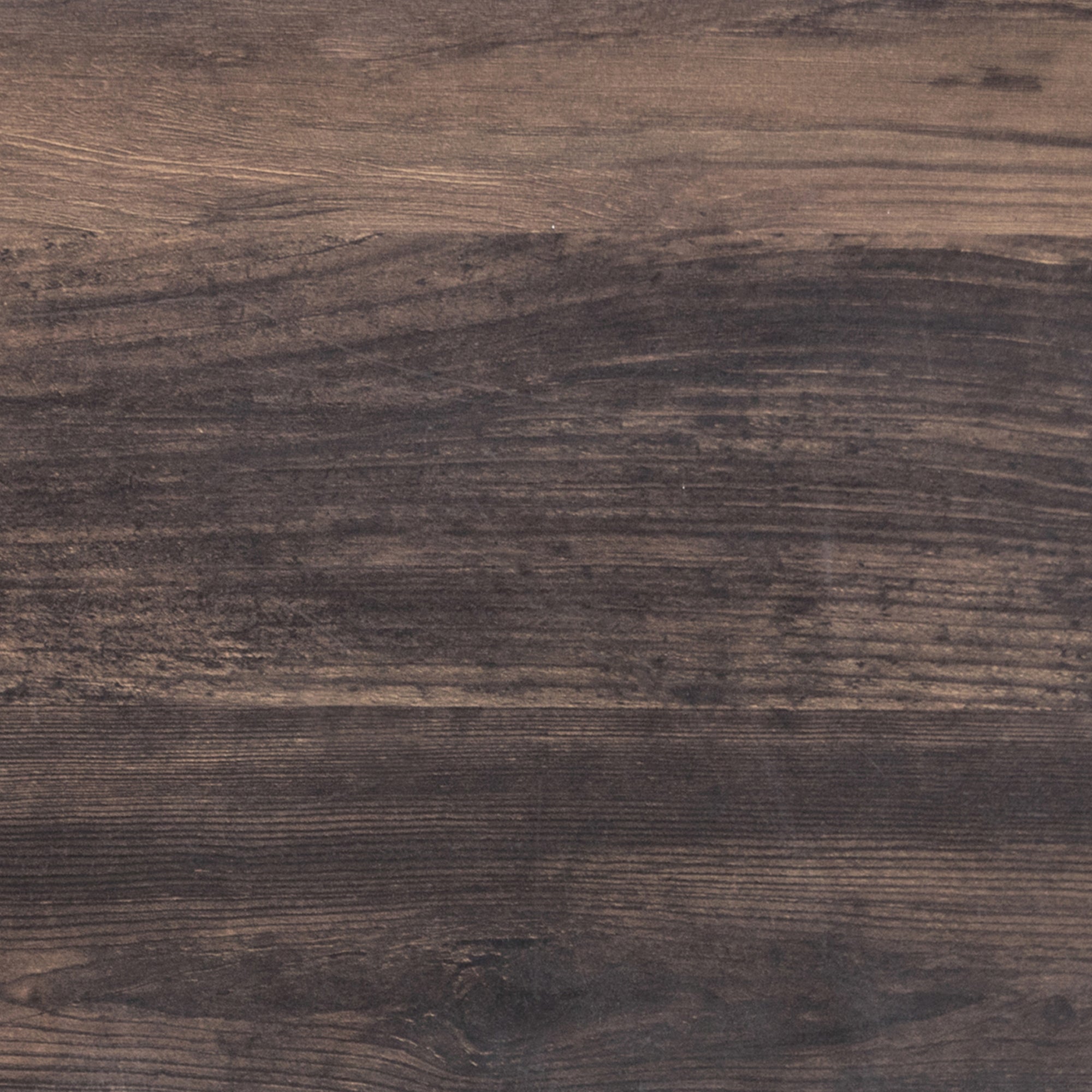 Close-up of a dark brown wooden surface with visible grain patterns and subtle texture variations. The wood has a natural, rustic appearance with shades ranging from medium to deep brown.