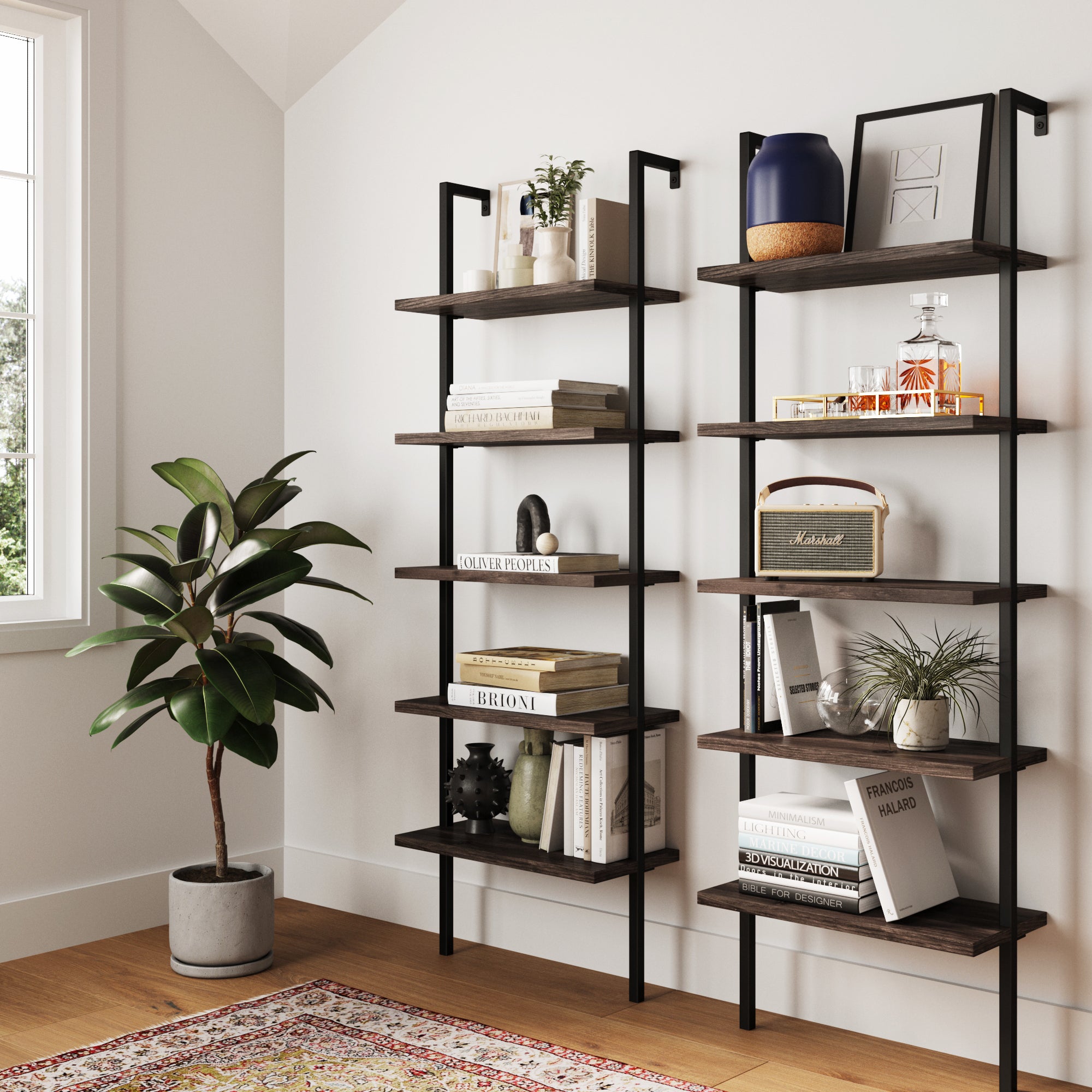 A modern living space features two Nathan James 5-Shelf Ladder Wall Bookshelves in Nutmeg displaying books, décor, and glassware. A potted plant sits on the wood floor by a window, with a colorful patterned rug partially visible.