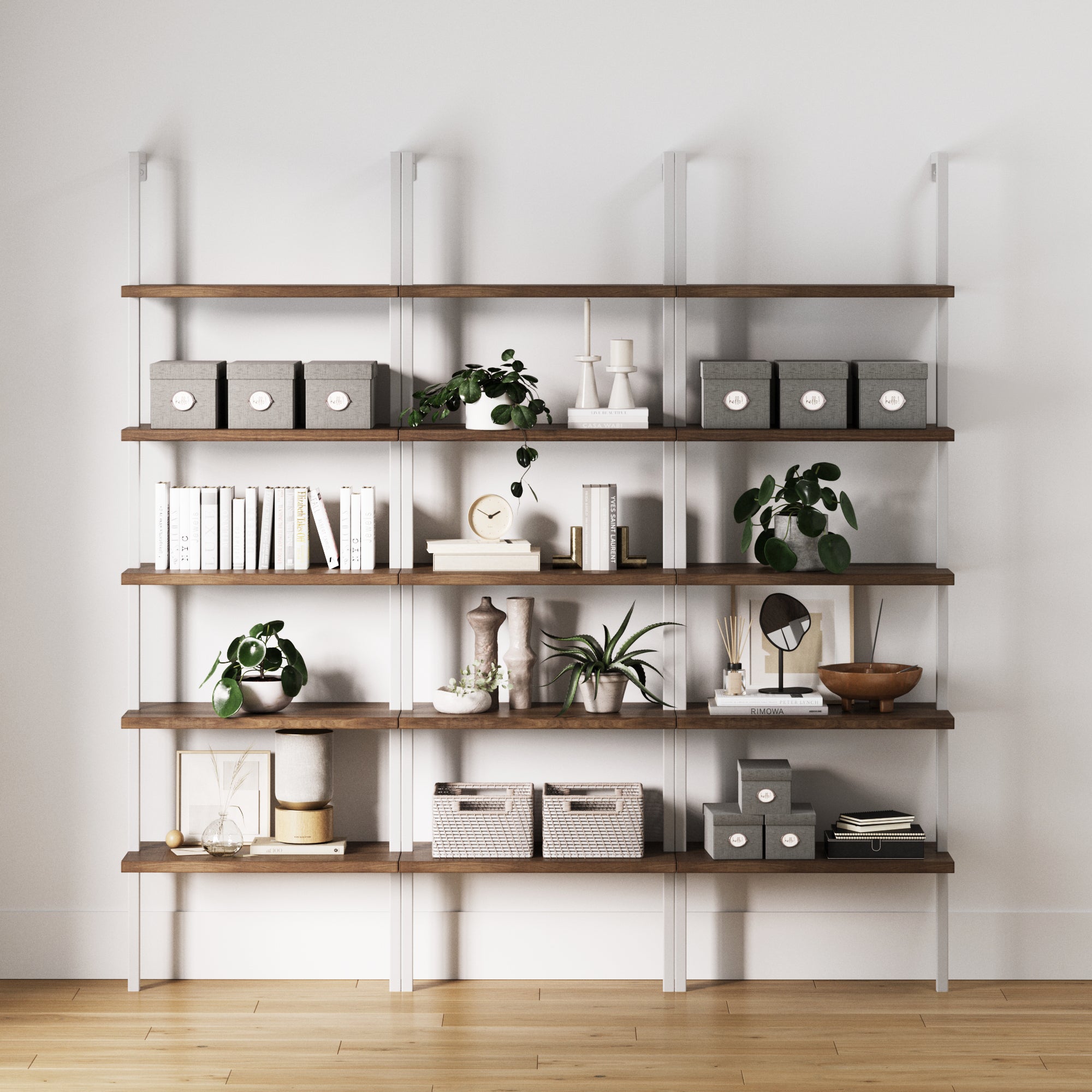 The Nathan James Ladder Bookshelf Oak Matte White Set of 3 features five rustic oak shelves to display books, storage boxes, plants, and decor. Perfect for stylish home office storage against a white wall on a light wood floor.