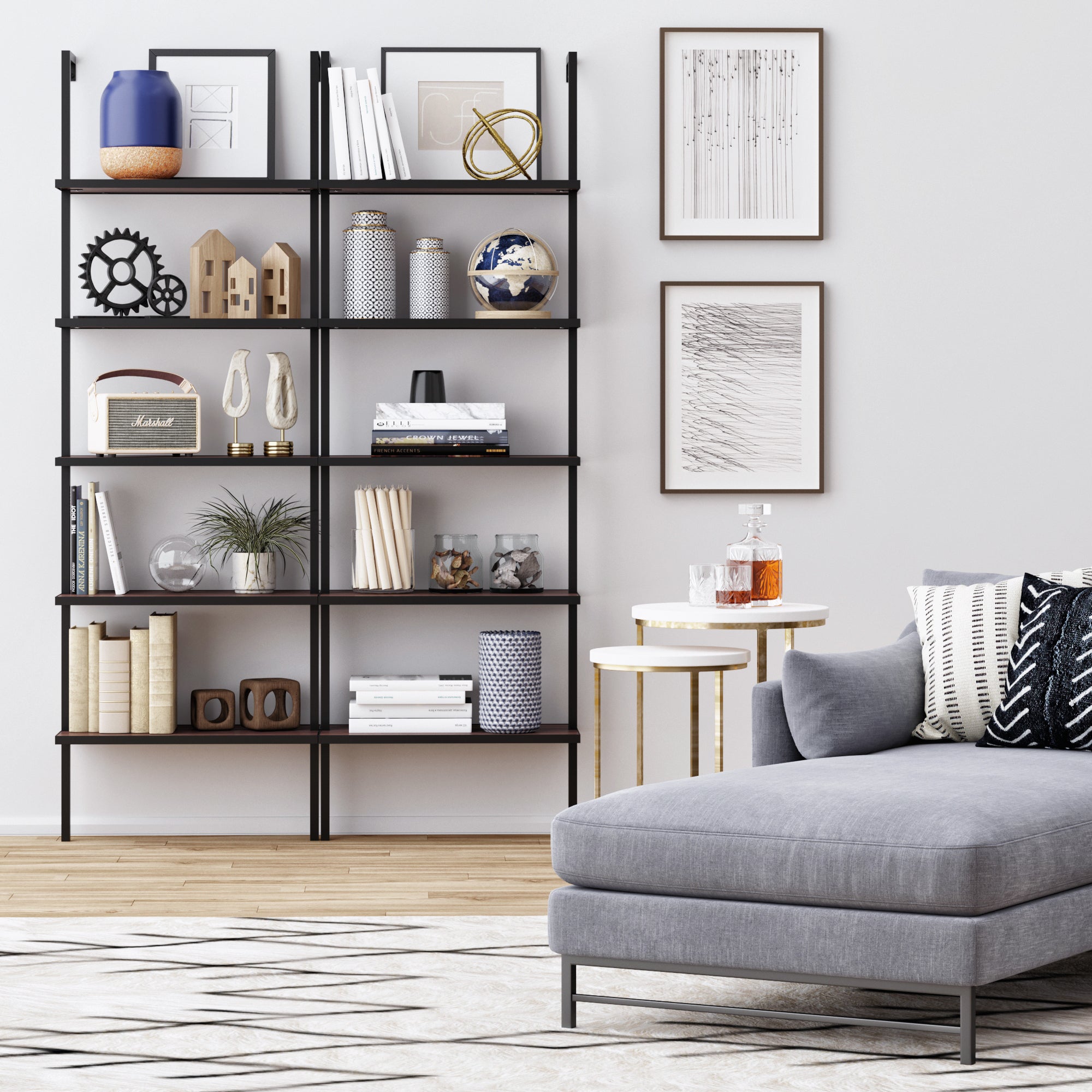 Modern living room featuring a gray sectional, patterned pillows, a white and gold side table with decanters, and the Nathan James 5-Shelf Ladder Bookshelf in Walnut Matte Black displaying books, vases, art, plants, and decor against a light wall.