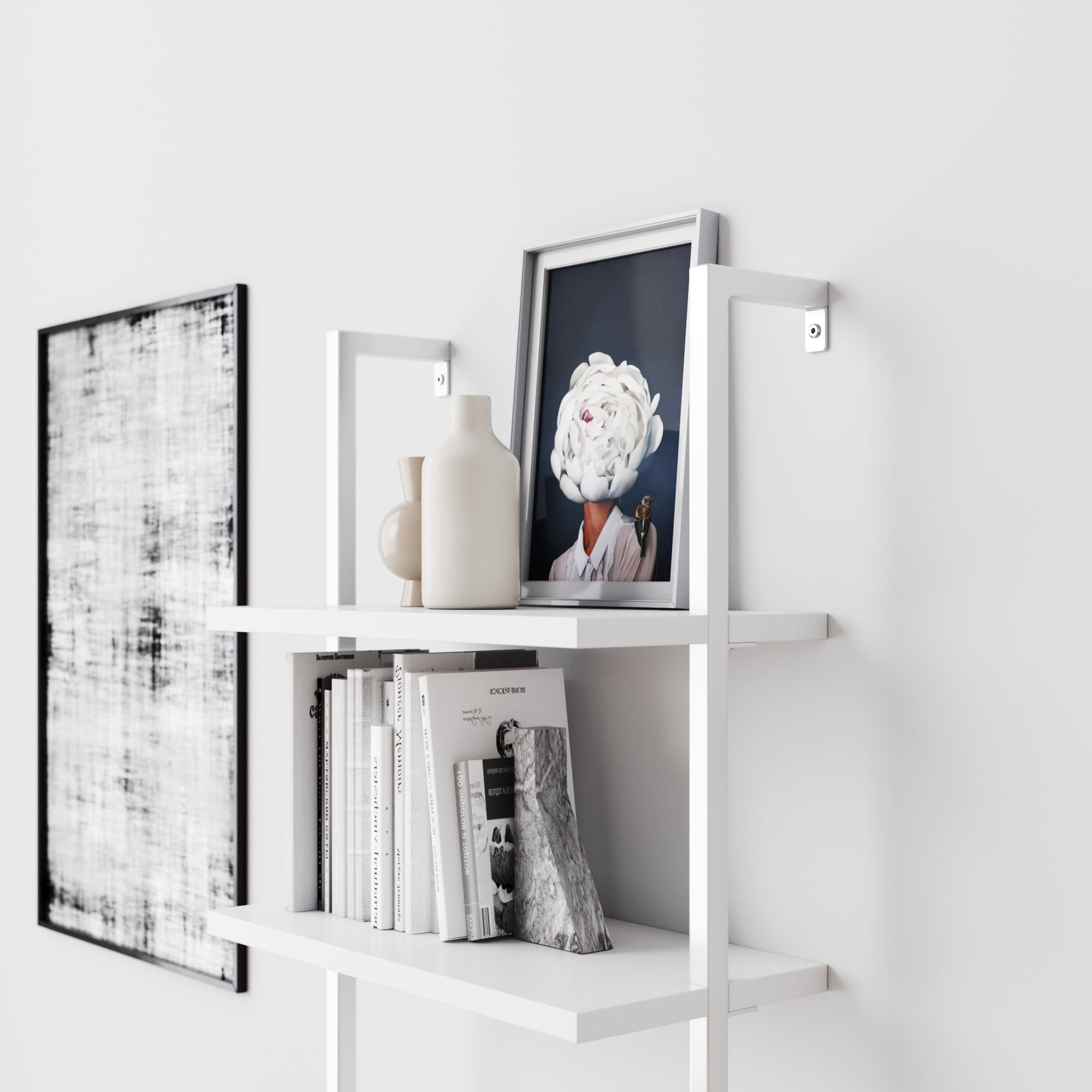 A white shelf holds books, two vases, and a framed photo of a person with a flower covering their face. A black-and-white abstract artwork hangs on the white wall beside the shelf.