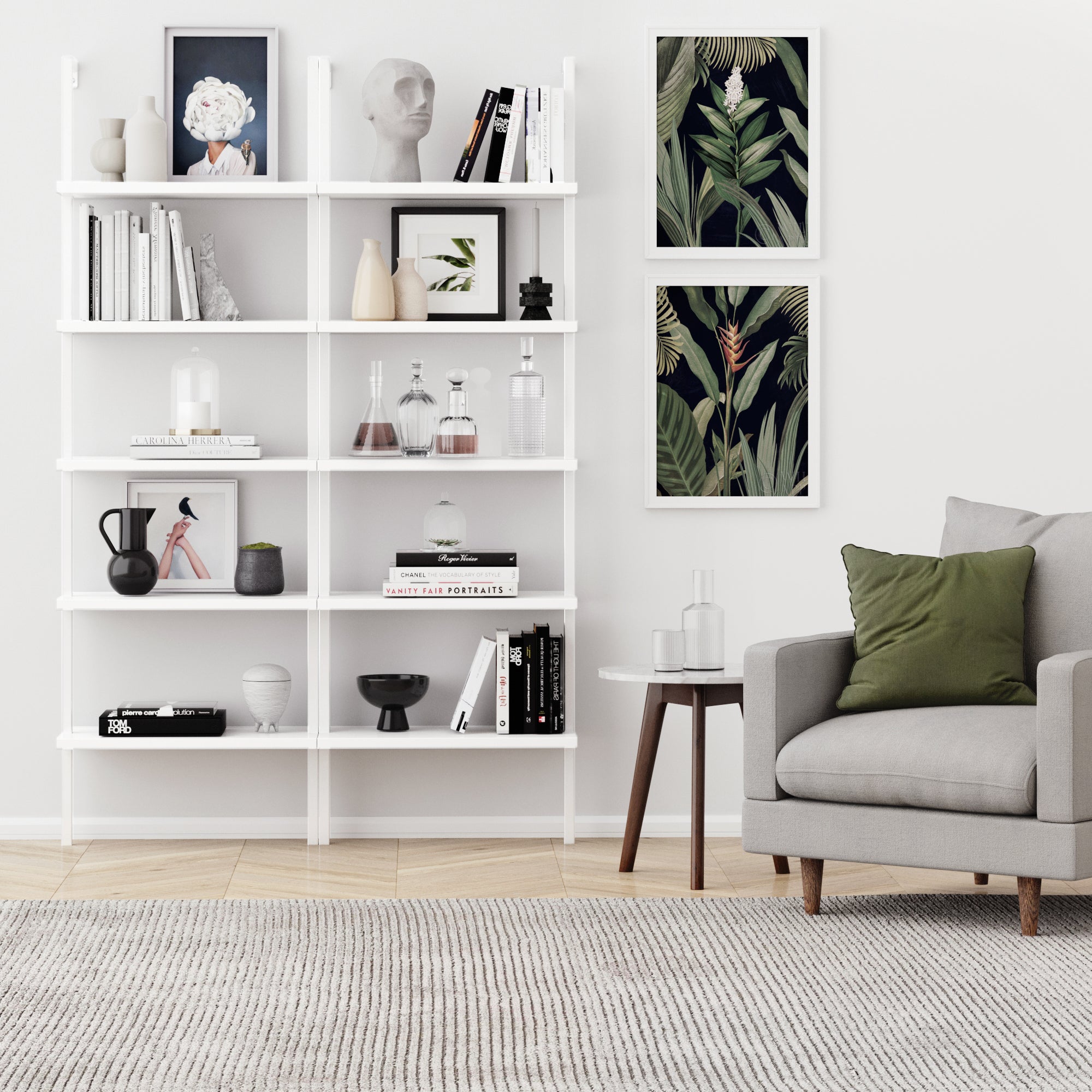 A modern living room features a gray armchair with a green pillow, side table, and the Nathan James 5-Shelf Ladder Bookshelf in white, styled with books, art, plants, and decor. Two botanical prints hang above a gray rug.