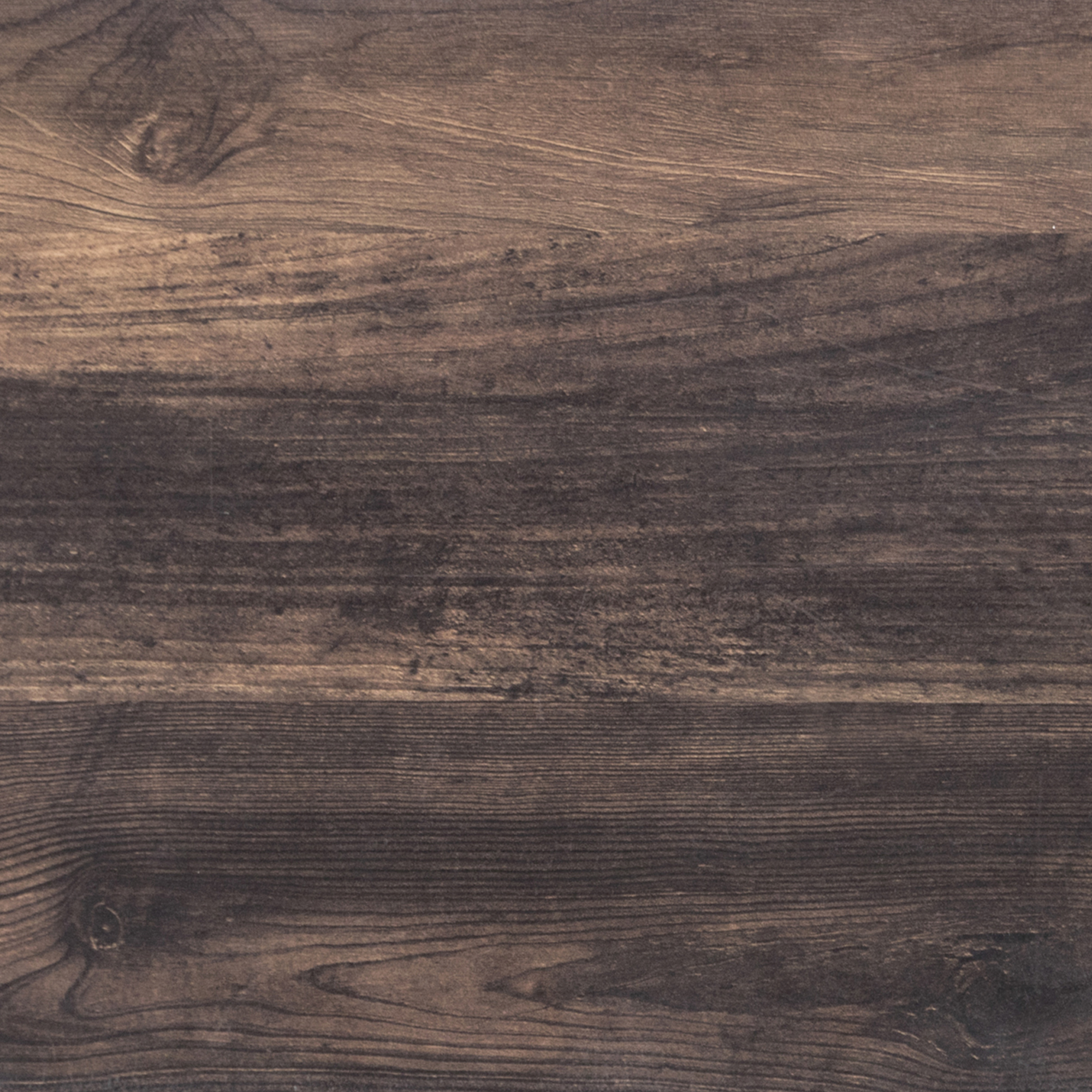 A close-up view of a dark brown wooden surface with visible grain patterns, knots, and textured lines running horizontally. The wood appears aged and rustic.