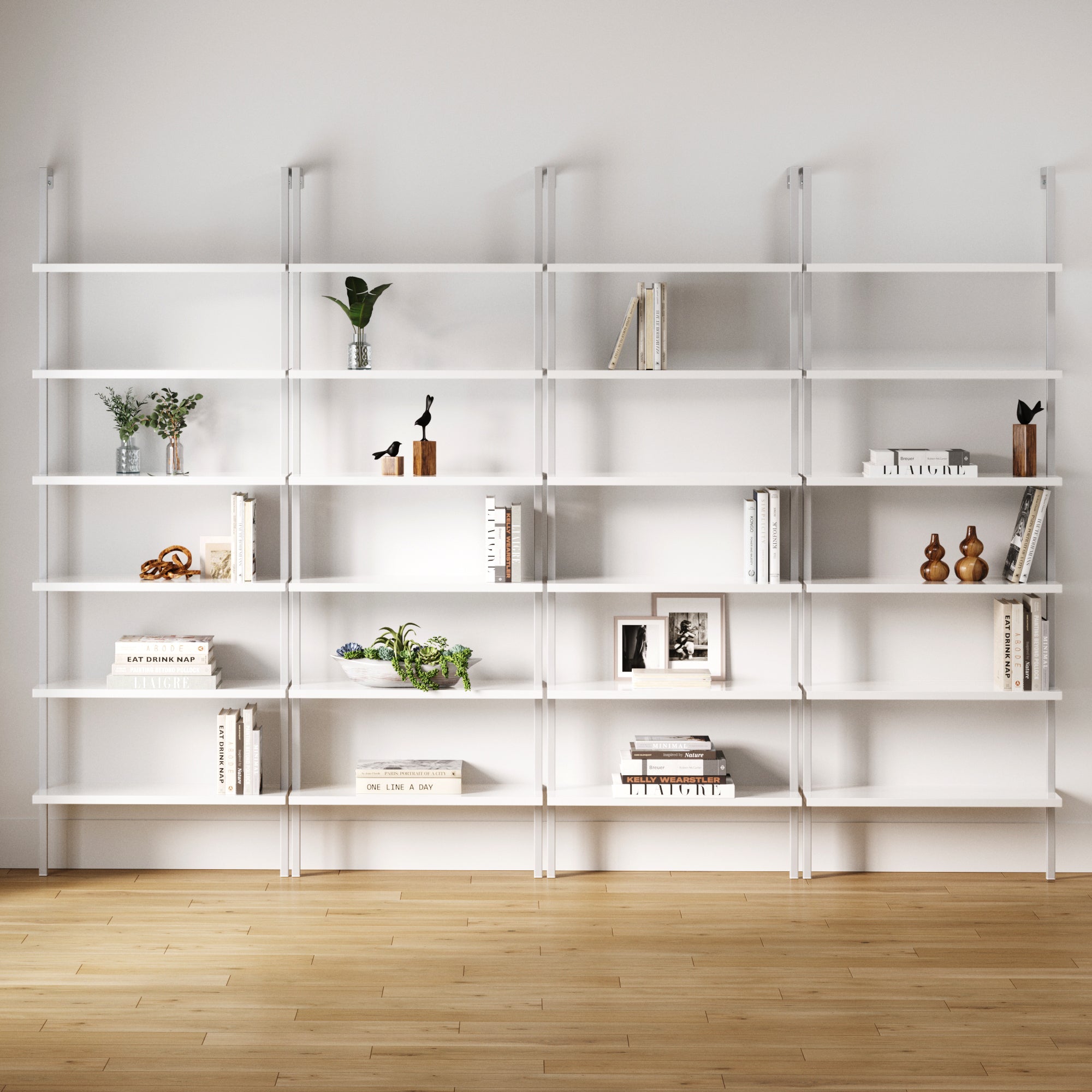 The Nathan James 6-Shelf Ladder Bookshelf in white (set of 4) offers six vertical shelves, wall-mounted on a wooden floor—perfect for showcasing books, plants, vases, and decor in a modern setting.