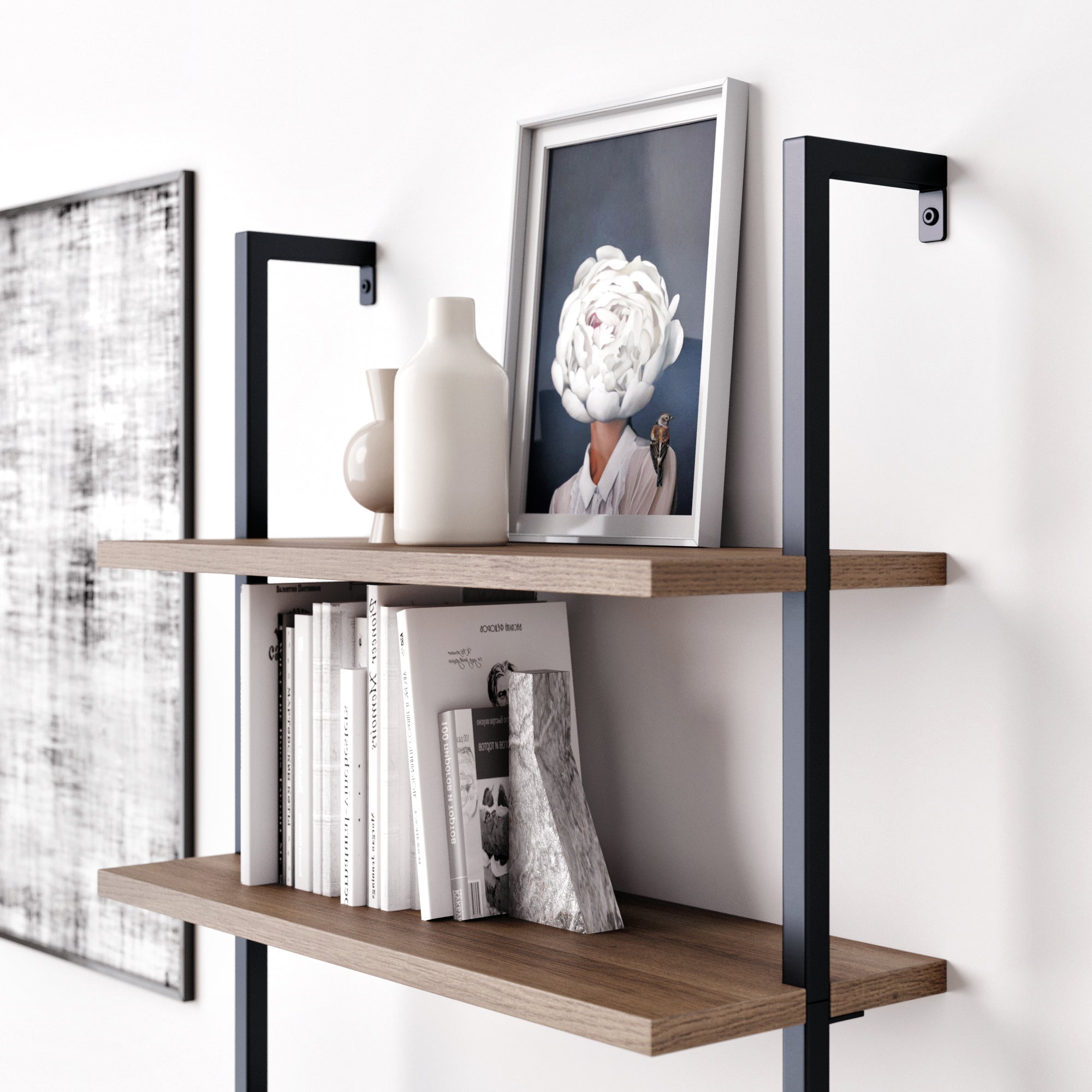 A modern wooden wall shelf with black metal supports holds white vases, books, and a framed portrait of a person with a large white flower obscuring their face. A monochrome artwork is partially visible on the wall nearby.