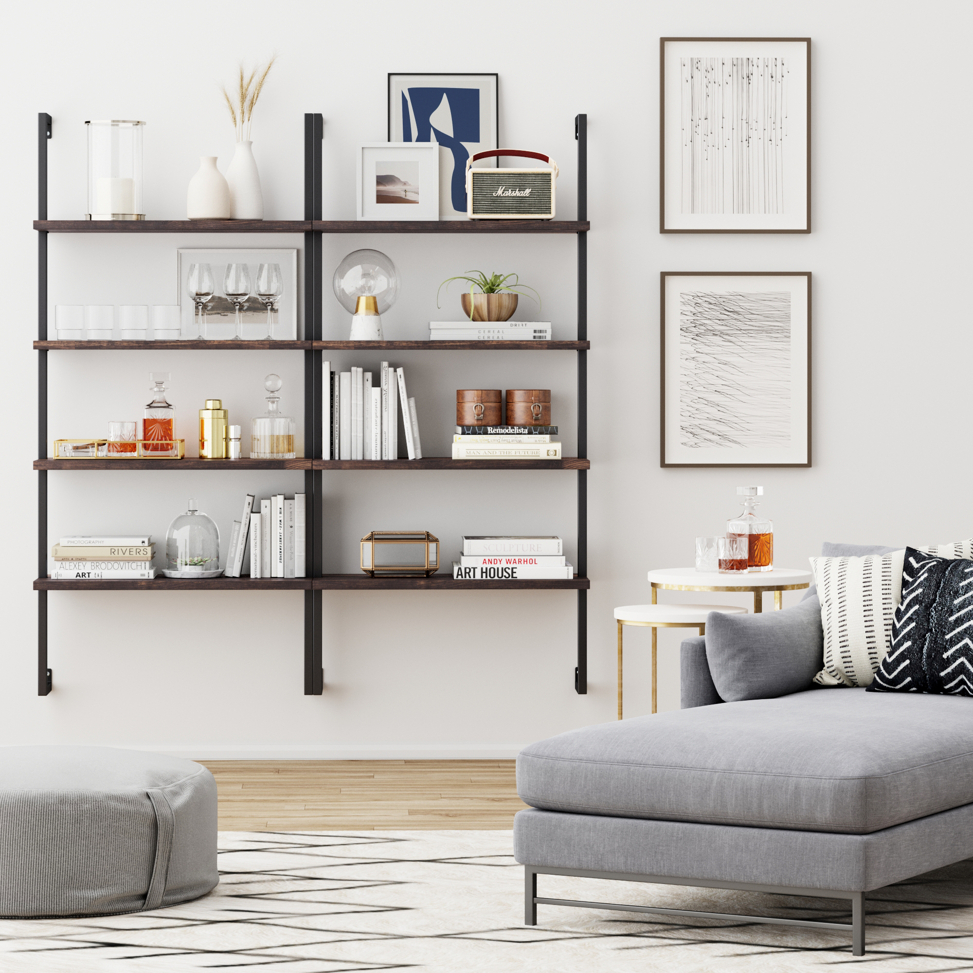 A modern living room featuring the Nathan James Wood & Metal 4-Shelf Floating Bookshelf in Nutmeg, displaying books, glasses, decor, and drinks. Abstract art hangs above a gray sofa with cushions, a round ottoman, and a geometric-patterned rug.