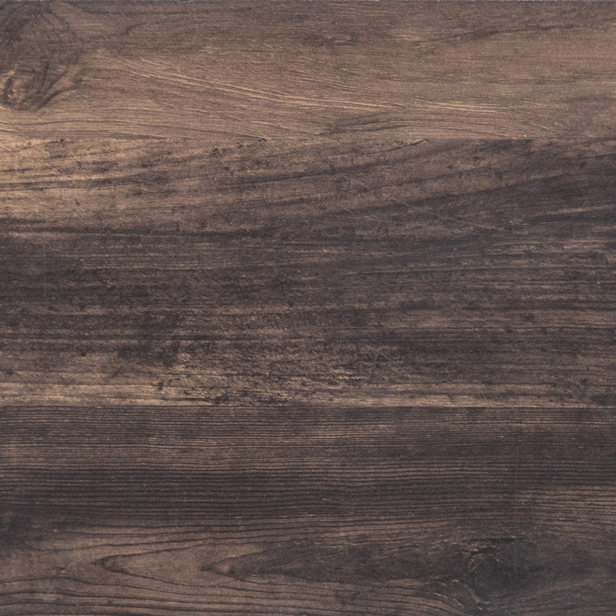 Dark brown wooden surface with visible grain patterns and subtle textures, showing natural variations in color and shading. The surface appears smooth and polished, highlighting the rich, rustic look of the wood.