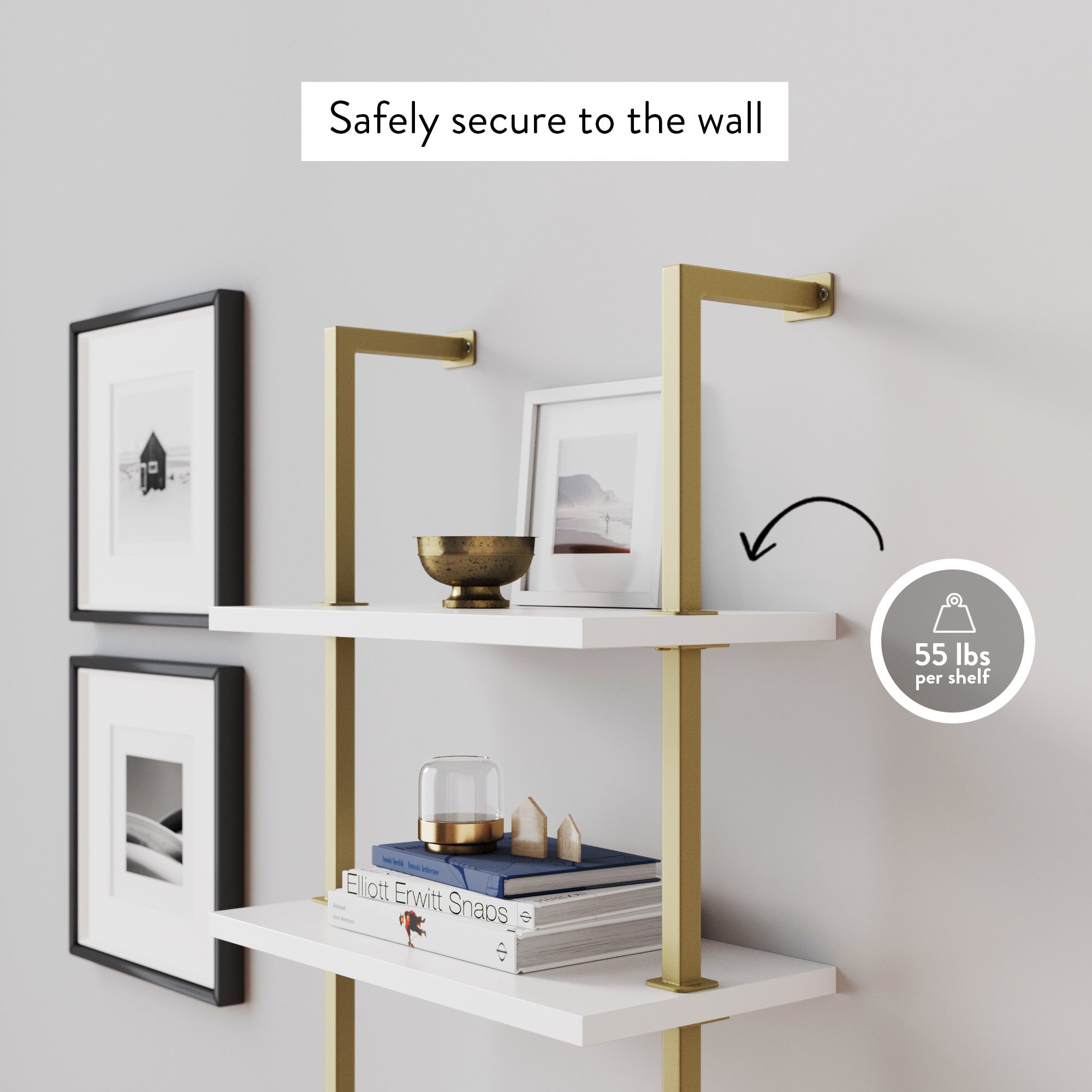 Two white shelves with gold brackets are mounted on a wall with framed photos. Text above reads Safely secure to the wall and a graphic indicates each shelf holds up to 55 lbs. An arrow points to the bottom shelf.
