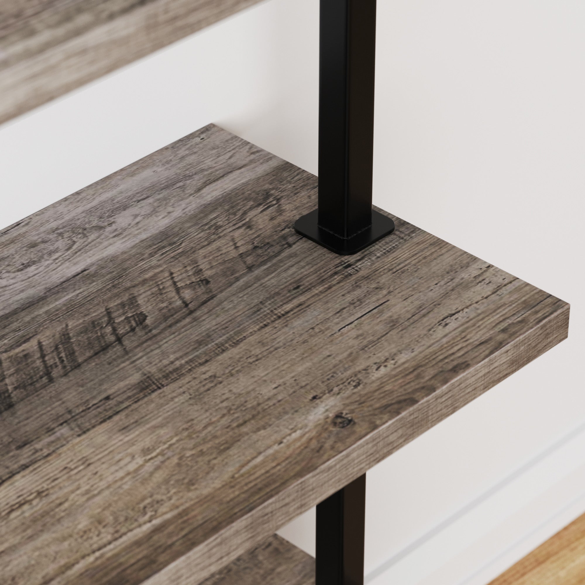 Close-up of a wooden shelf with a rustic, weathered finish, supported by a black metal frame, against a white wall and light wood floor.