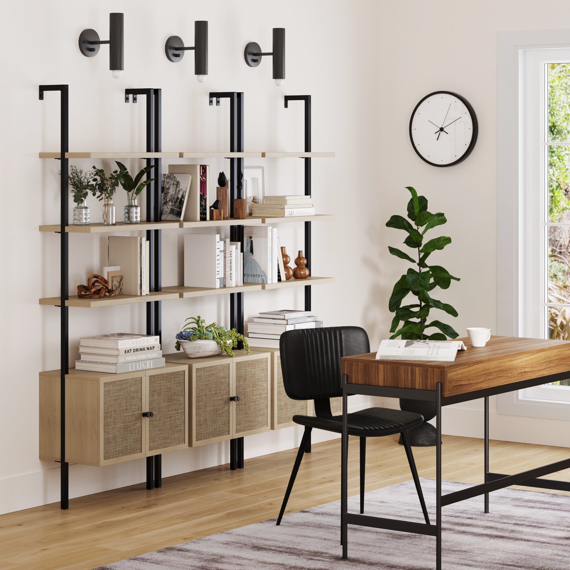 A modern home office with a wooden desk, black chair, potted plant, round wall clock, and three Nathan James Rattan Ladder Wall Bookshelves with Doors in Light Oak above the desk. Books and decor are neatly stored, and natural light streams through the window.