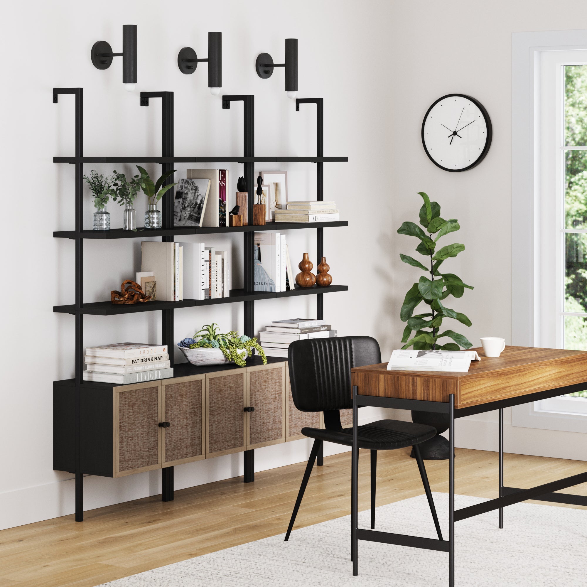 Modern home office with a wooden desk, black chair, potted plant, wall clock, and three Nathan James Rattan Ladder Wall Bookshelves with Doors Black (Set of 3), styled with books and decor near a large window.
