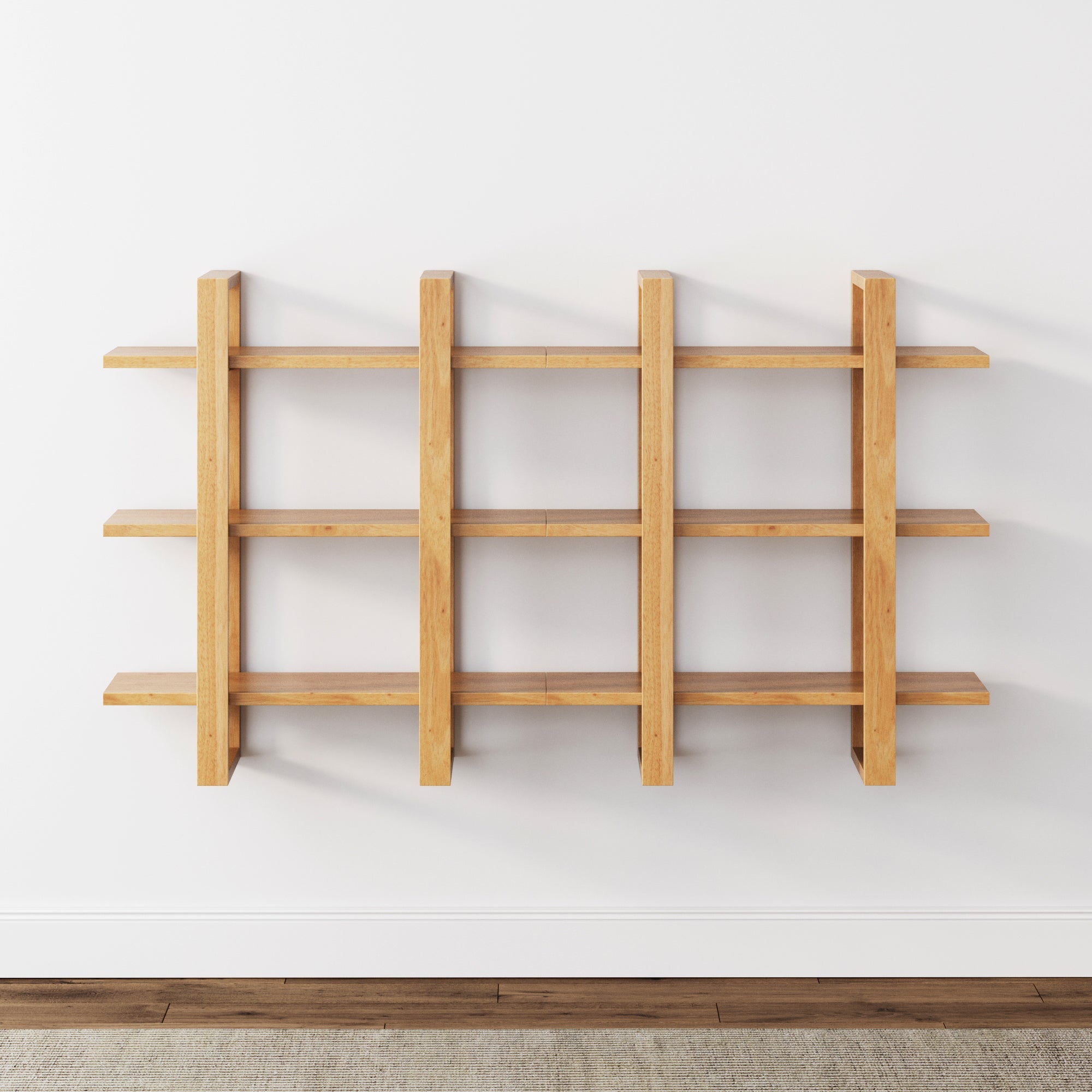 The Nathan James Solid Wood Wall Shelves Warm Pine (Set of 2) feature a modern grid design with three horizontal and three vertical panels, serving as a modular bookcase on a white wall above a wooden floor and light rug.