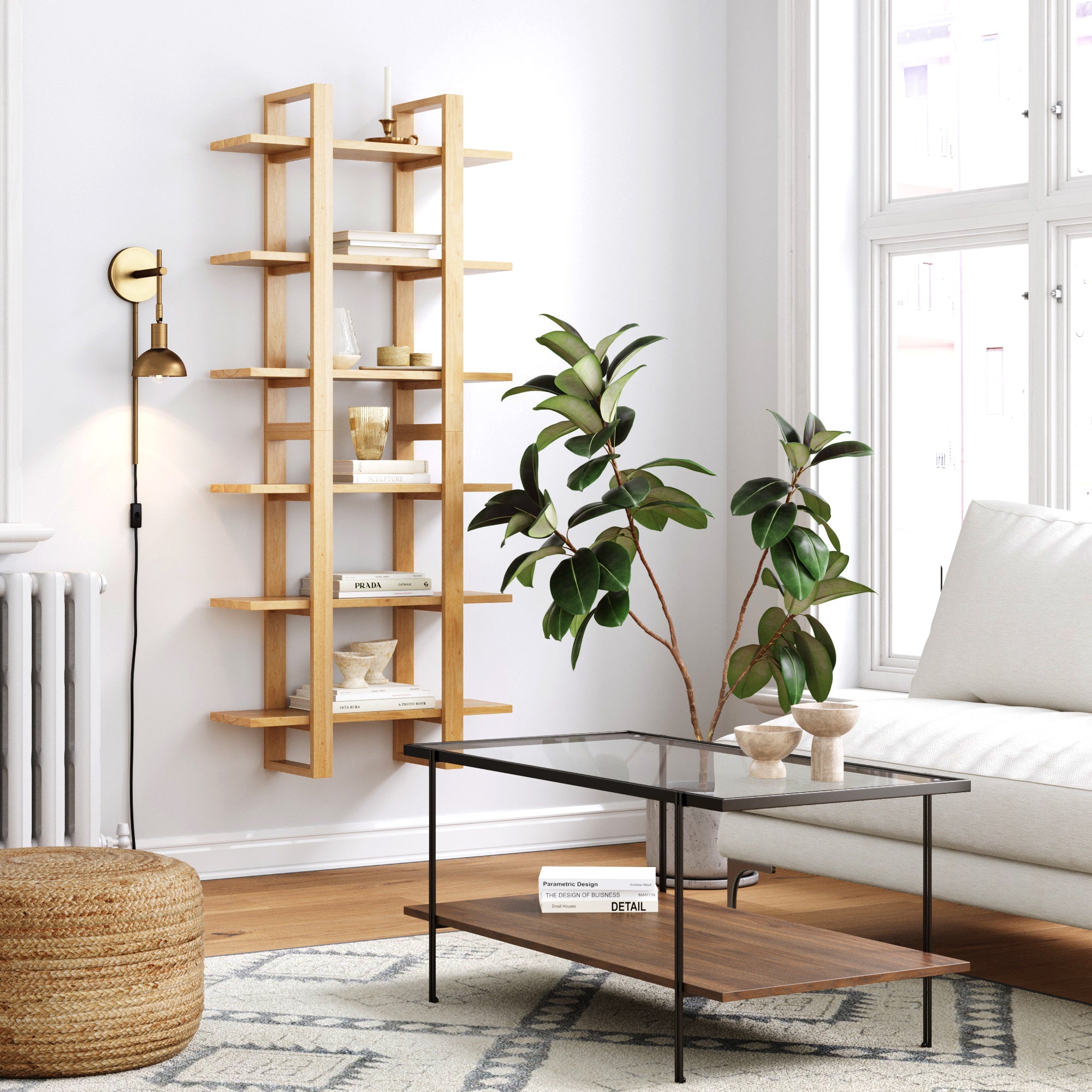 A modern living room with a light wood wall shelf holding books and decor, a glass coffee table, a potted plant, a white sofa, a woven pouf, and a black floor lamp by large windows.