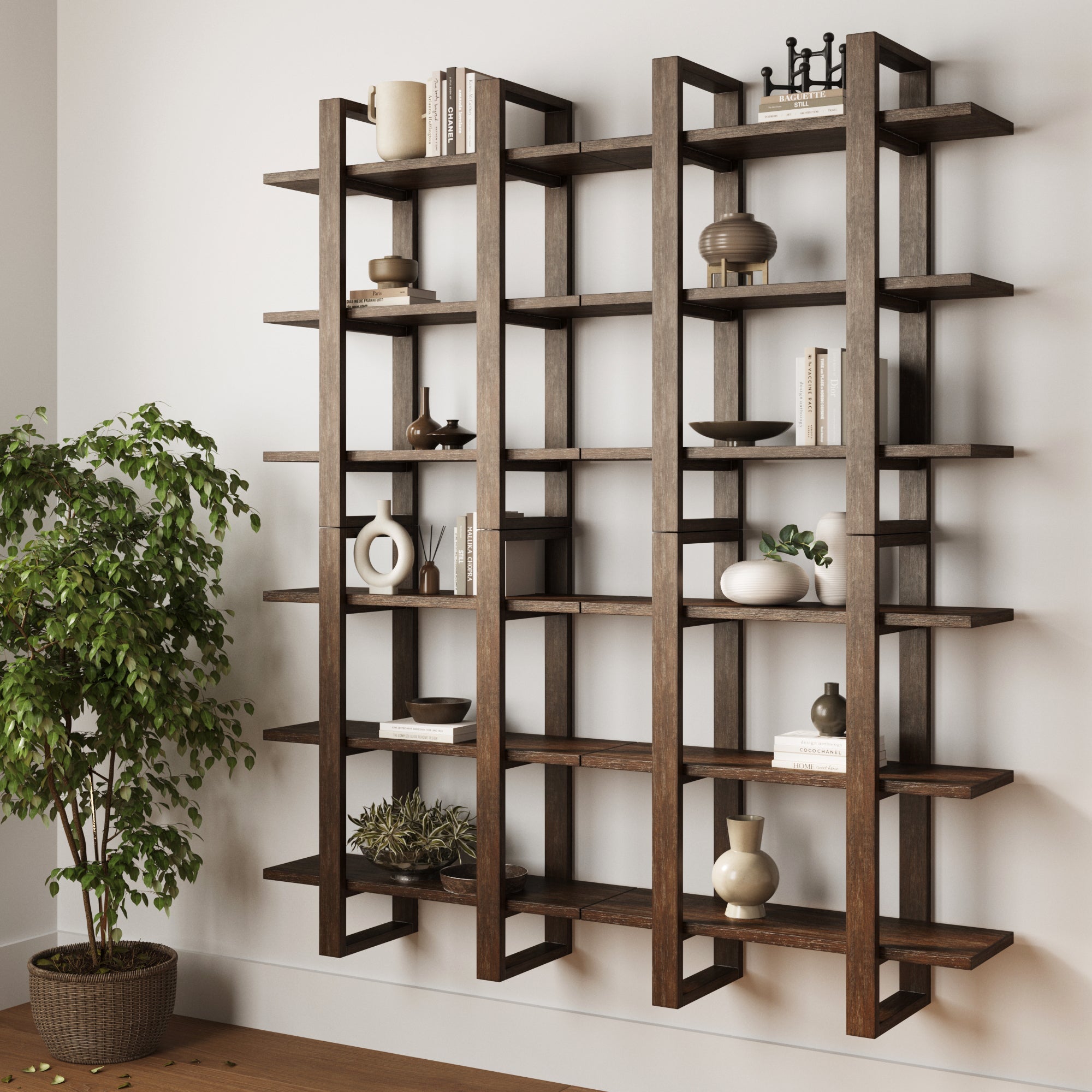 Nathan James Solid Wood Wall Shelves in dark brown (set of 4) display minimalist decor like vases and bowls. The durable, wall-mounted shelves add style, while a leafy potted plant sits on the floor nearby.
