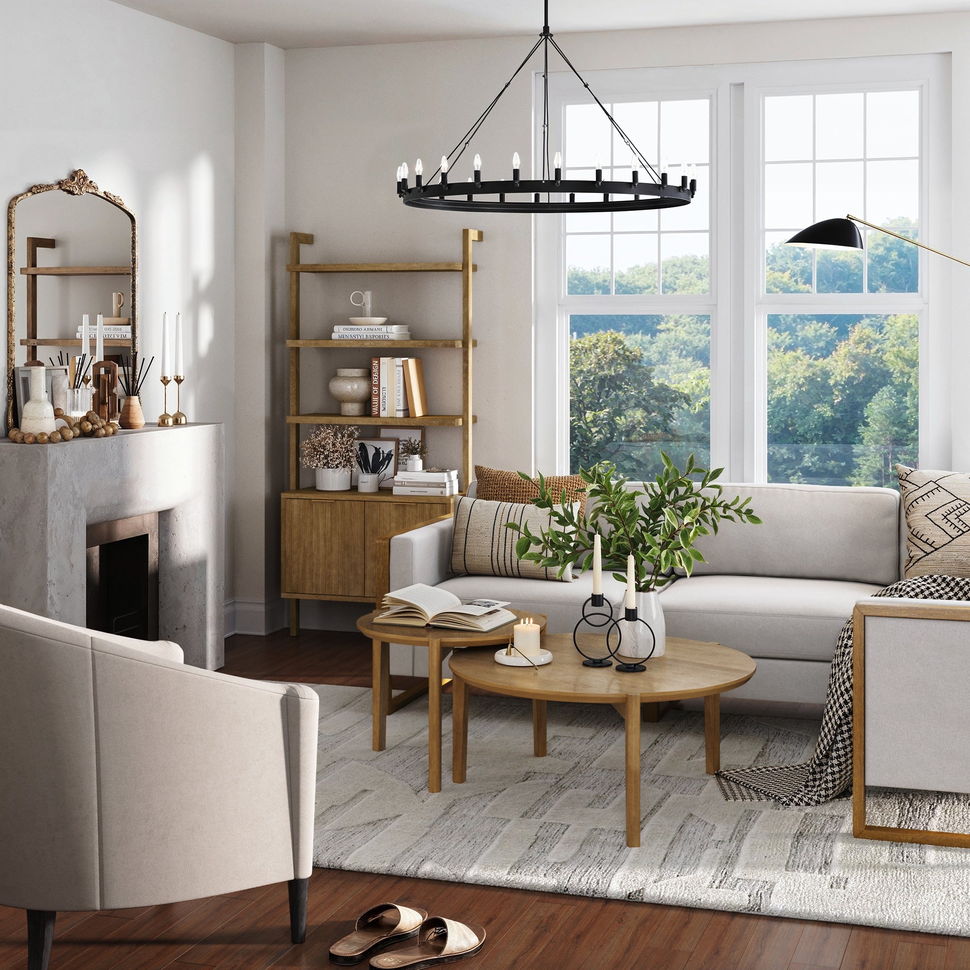 A bright living room with large windows, a white sofa, light armchair, round wooden coffee tables, decorative candles, green plant, a Nathan James Mid-Century Fluted Wall Bookshelf with Doors in light brown, fireplace, mirror, and modern black chandelier.