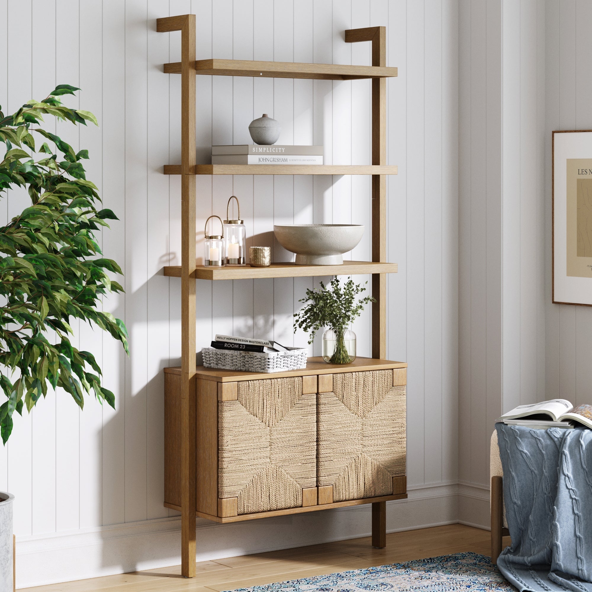 The Nathan James Seagrass Wall Bookshelf with Doors in light brown displays lush plants, adding a natural touch to the room.