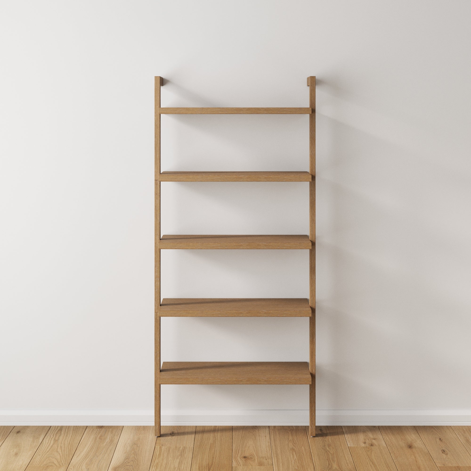 A simple, empty wooden ladder-style bookshelf with five shelves stands against a plain white wall on a hardwood floor.