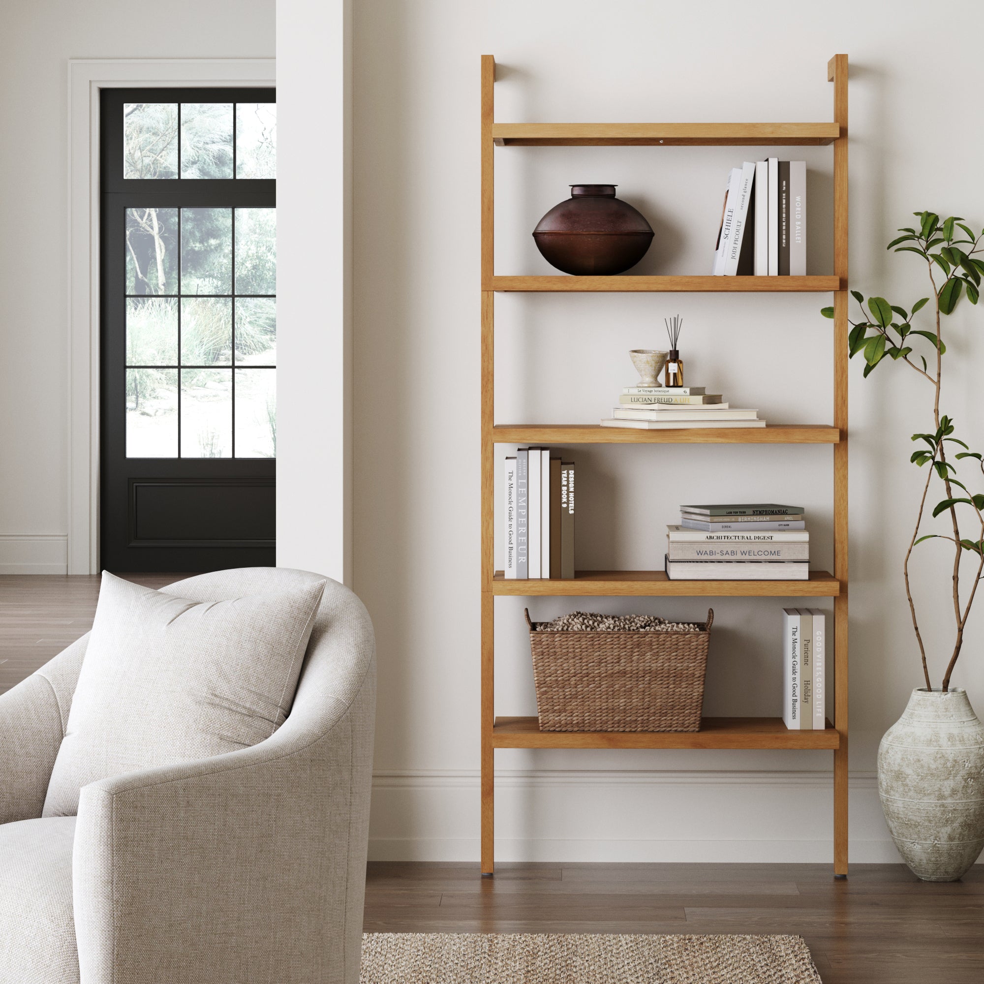The Nathan James Wood 5-Shelf Ladder Wall Bookshelf in Warm Pine displays a brown vase, books, small decor, a potted plant, and a woven basket. A beige armchair sits nearby by a large window and black door.
