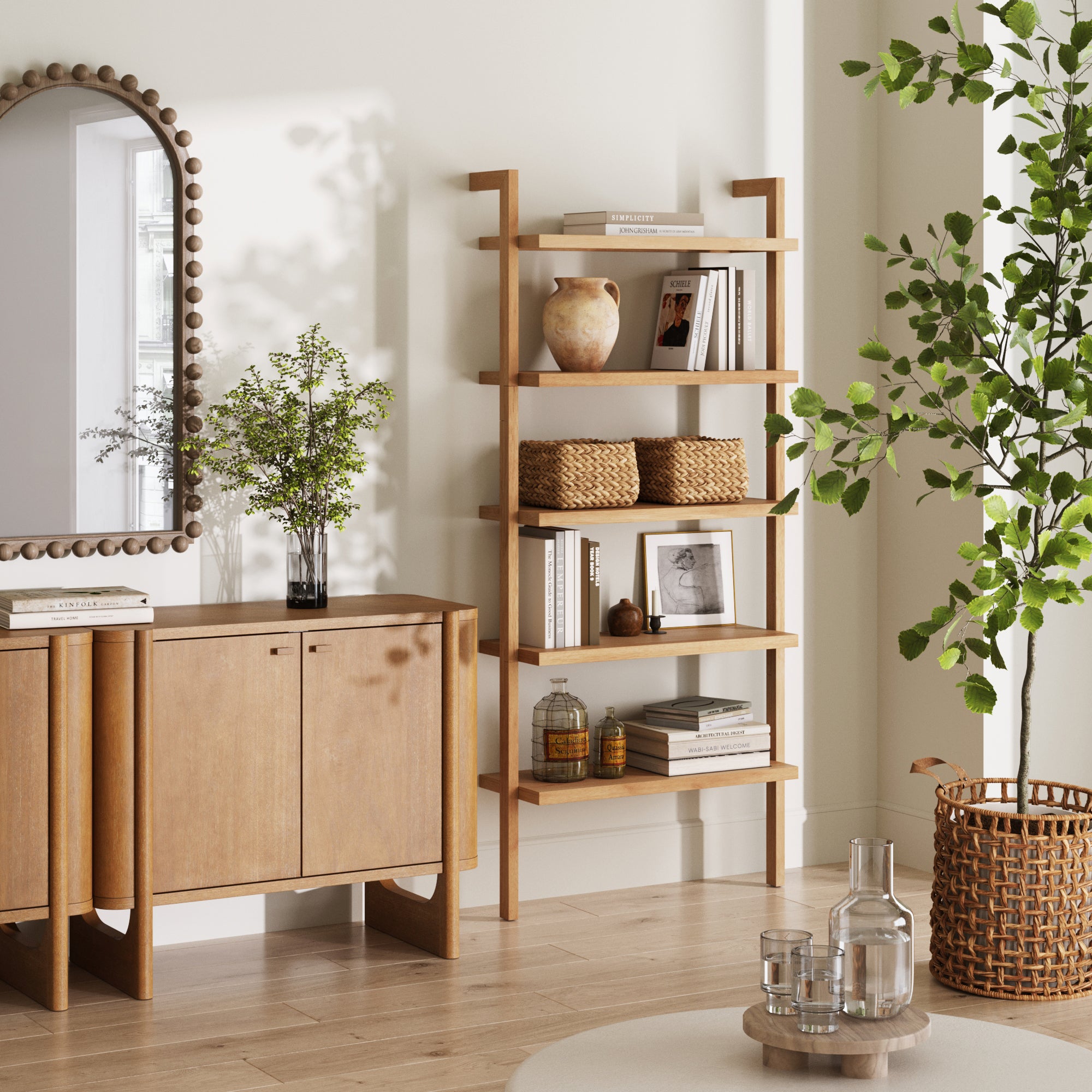 A modern living room with light wood furniture features the Nathan James Wood 5-Shelf Ladder Wall Bookshelf in Warm Pine, a sideboard, open shelving with baskets and vases, a leafy potted plant, round mirror, and soft natural light.
