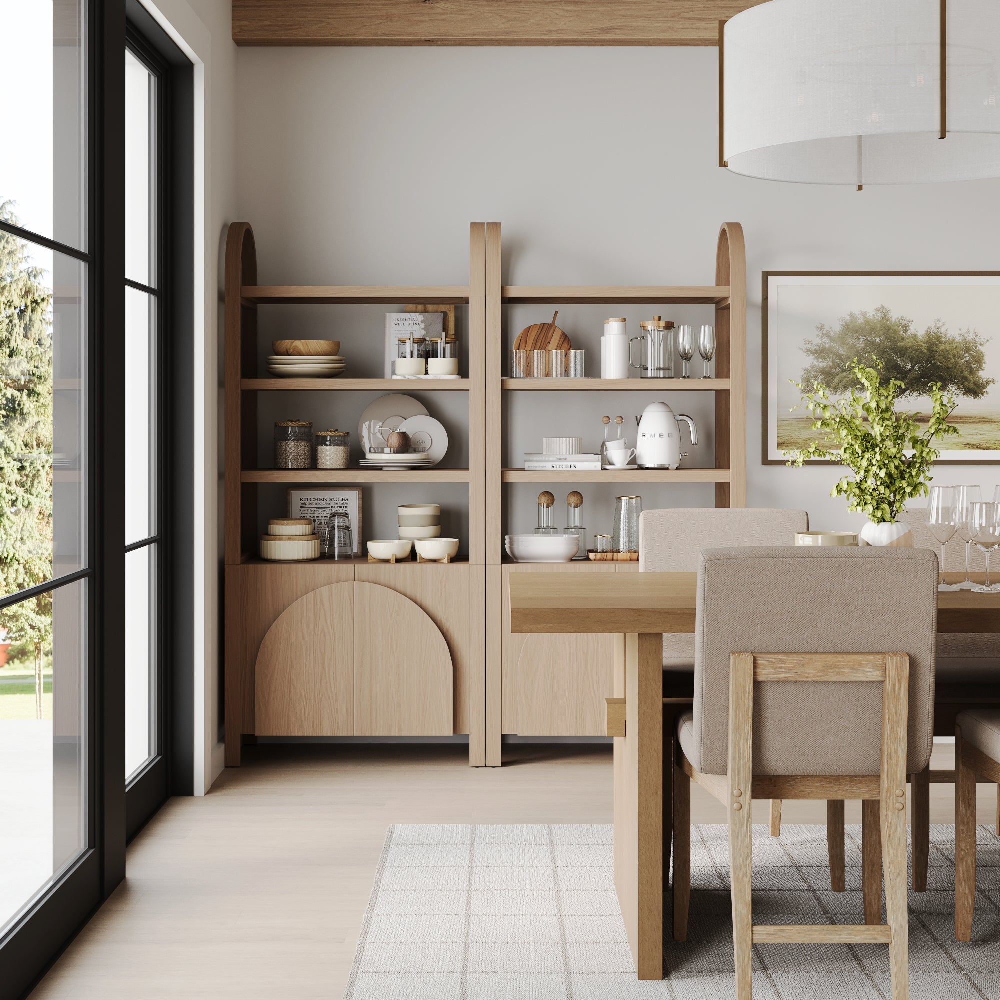 A modern dining room with light wood furniture, open shelving, a rectangular table with beige chairs, a large window, rug, and framed art features two Nathan James Mid-Century Arched Door Bookshelves with Doors in Raw Oak.