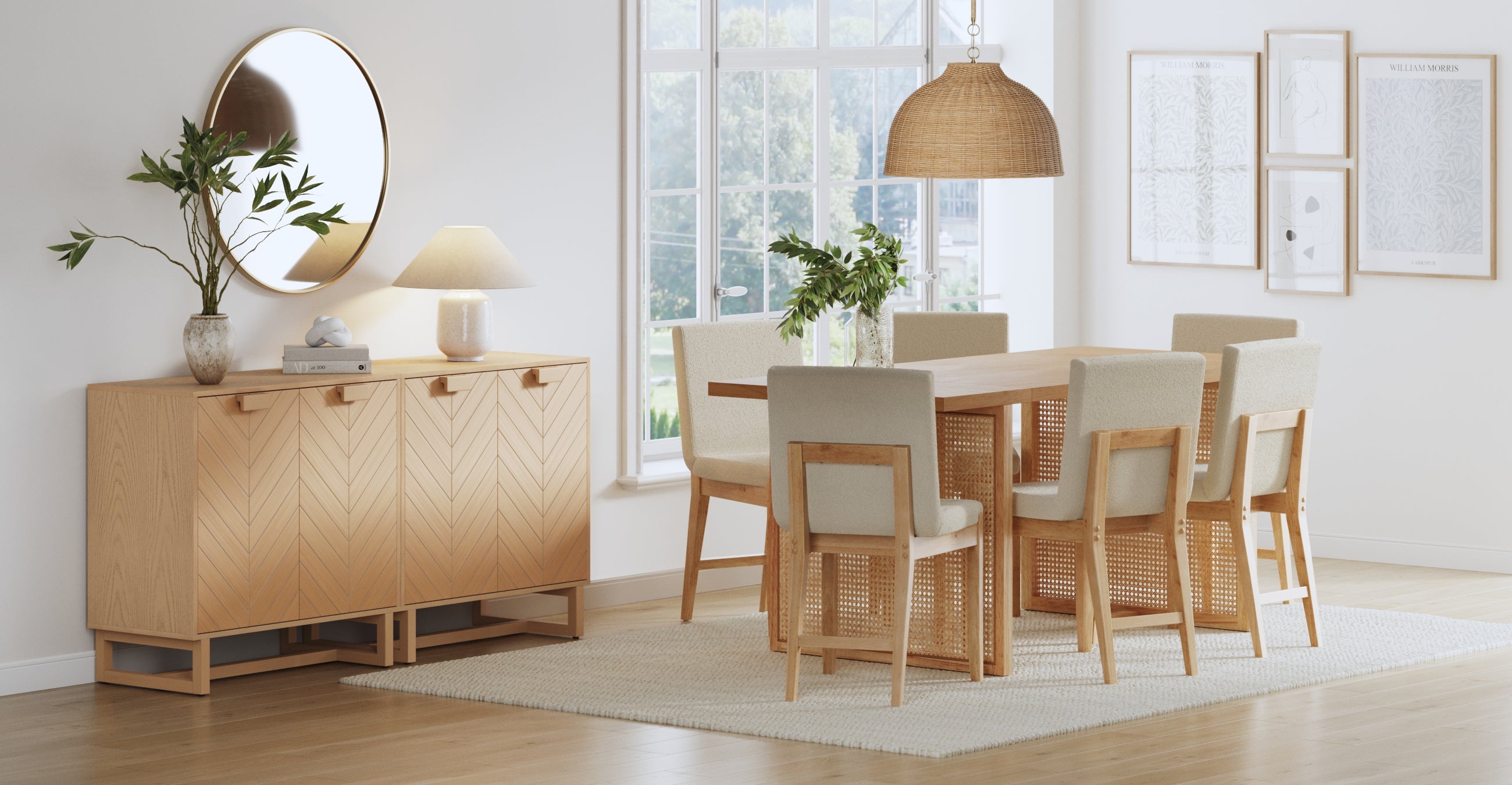 A modern dining room with a wooden table, six beige cushioned chairs, a sideboard with plants and a lamp, a round mirror, framed wall art, large window, and a woven pendant light above the table.