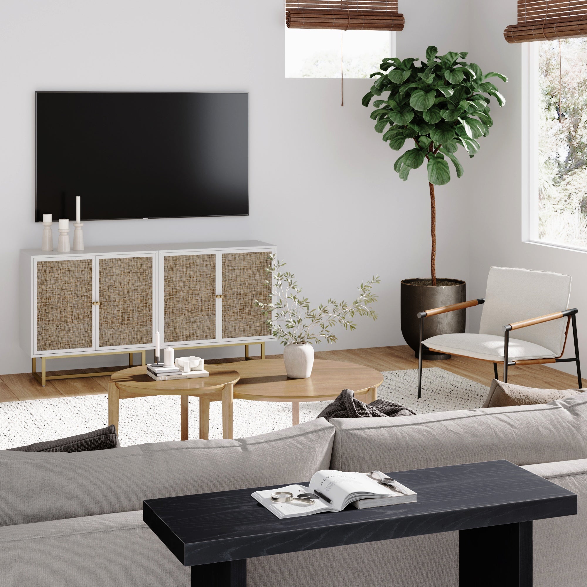 Modern living room with a wall-mounted TV, a console with woven cabinet doors, a potted plant, a white armchair, a round coffee table, a sofa, and decor including candles and a small vase on the table.