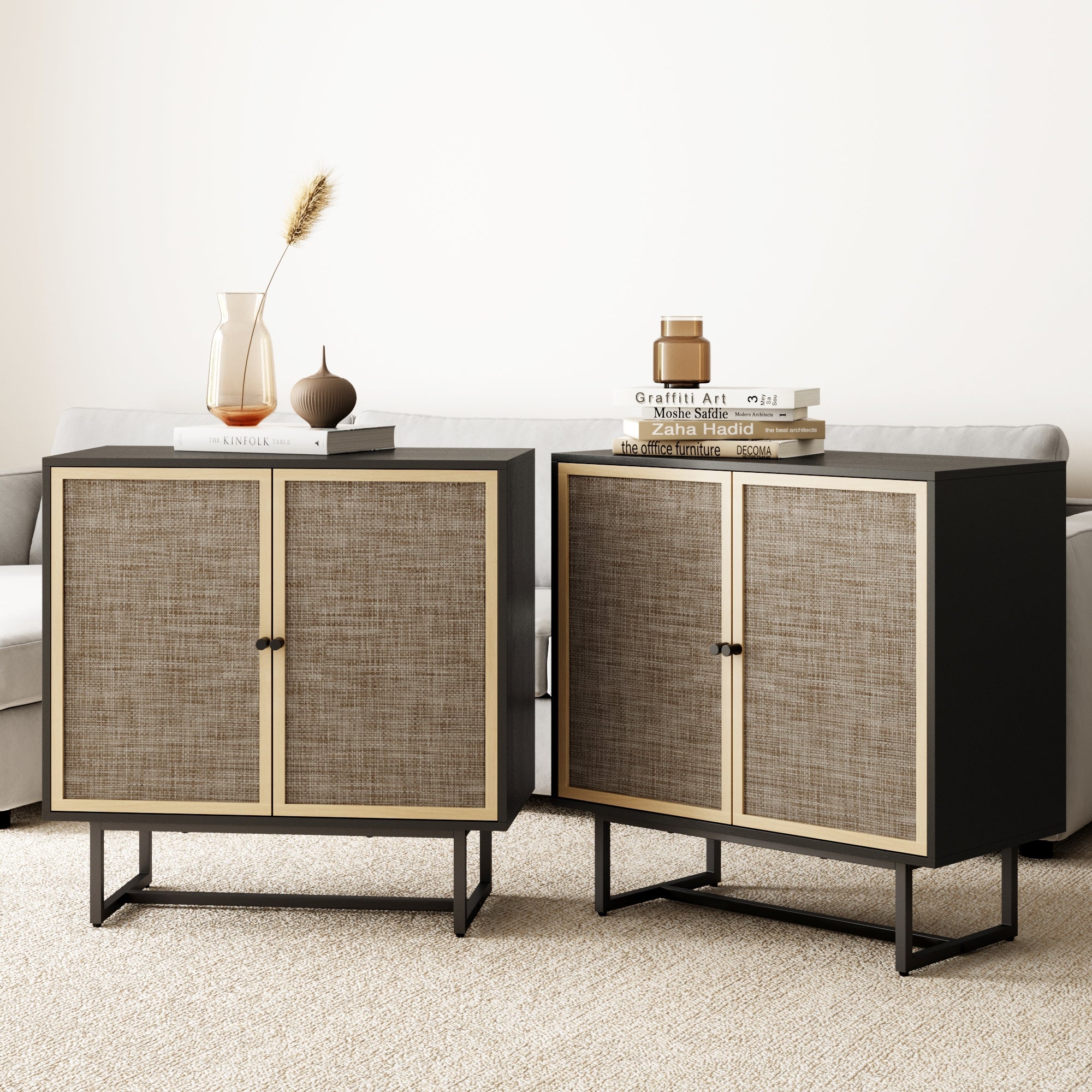 Two modern side cabinets with woven rattan doors and black frames stand on a beige carpet, side by side. The left cabinet has decorative vases on top; the right cabinet holds a stack of books. A sofa is visible in the background.