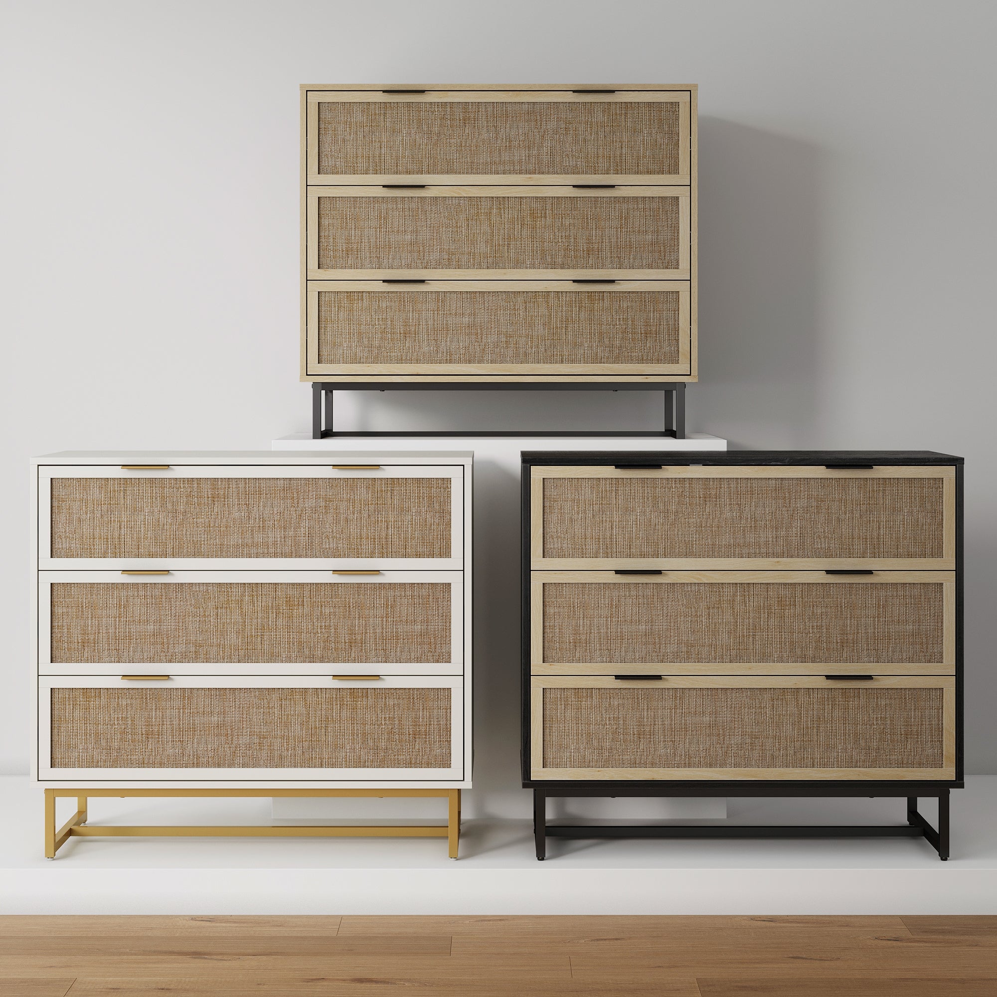 Three modern dressers with woven rattan drawer fronts are displayed against a white wall. The dressers are in white, black, and beige frames, each with three drawers and metal legs, standing on a light wood floor.
