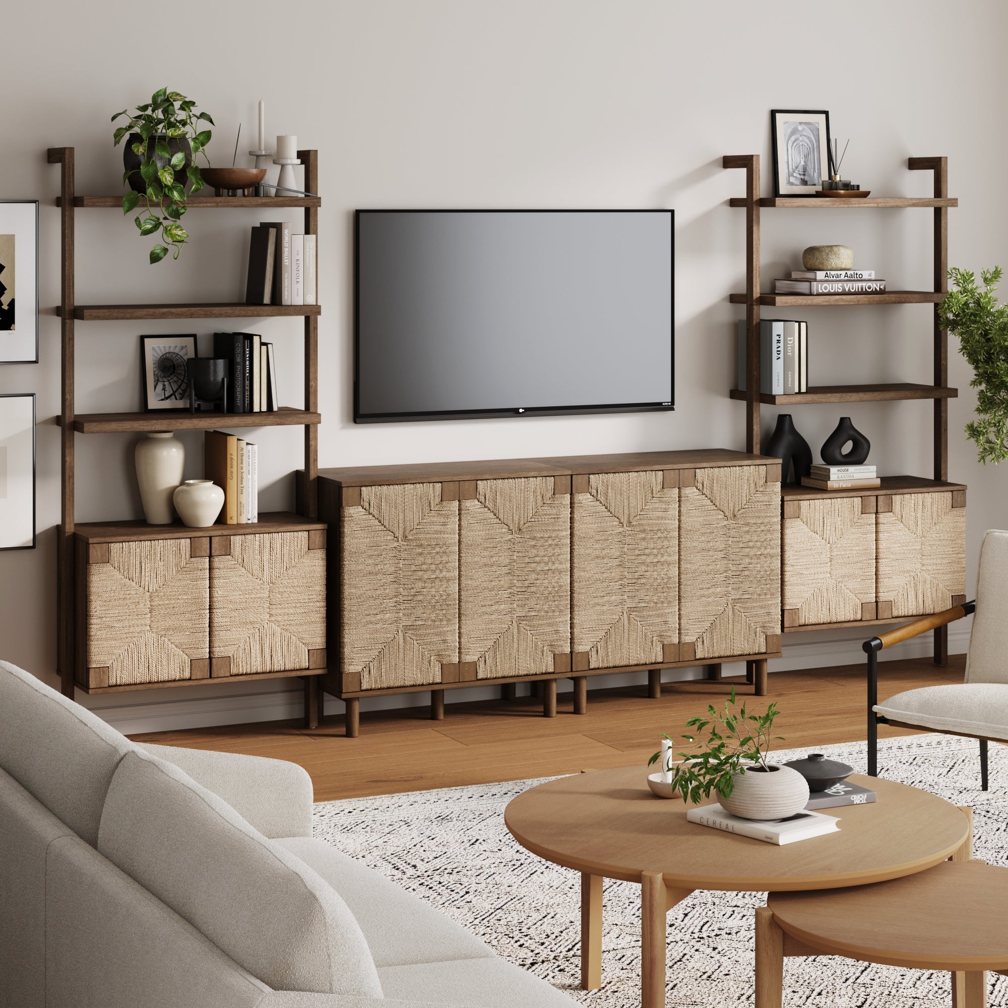 A modern living room featuring the Nathan James Seagrass TV Wall Unit in dark brown (2 cabinets), wooden shelves with plants and decor, a light sofa, round wooden coffee table, textured wood veneer cabinets, and a patterned rug on a light floor.