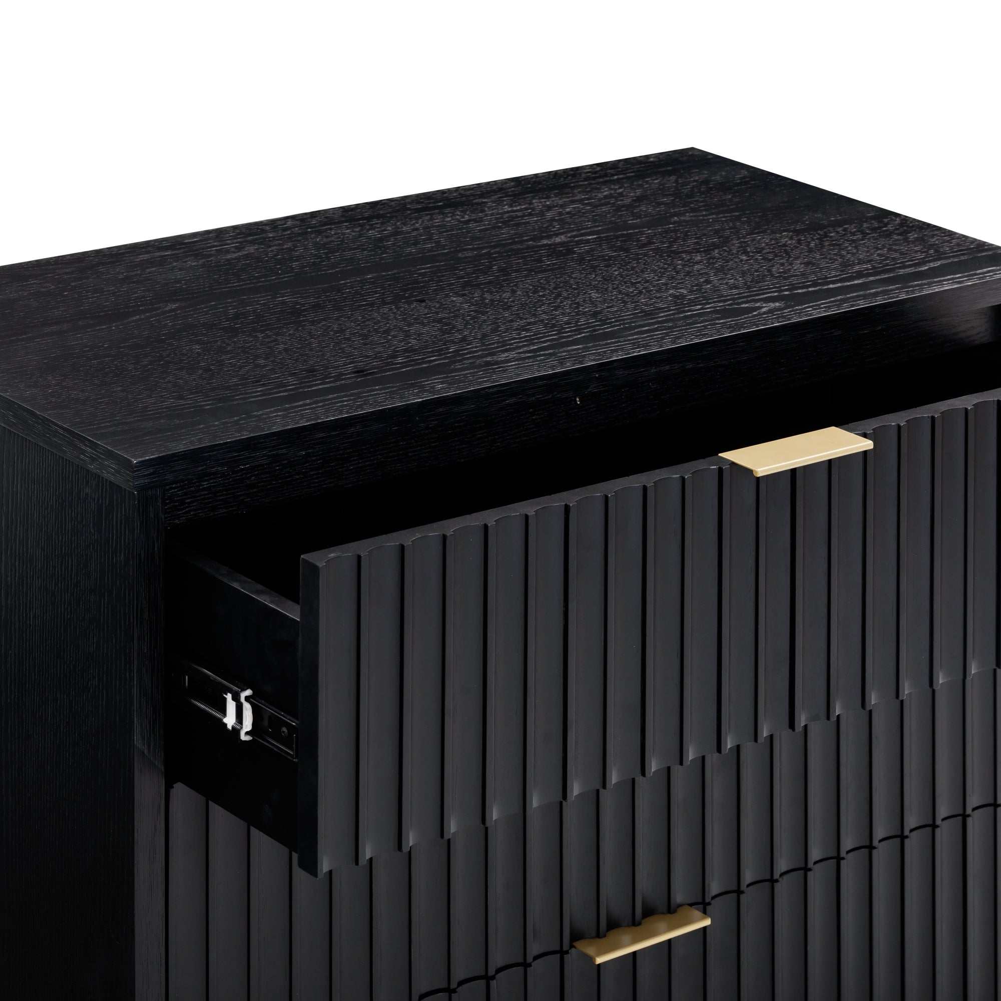 A close-up of a modern black wooden dresser with gold handles, showing the top drawer partially open. The dresser features a vertical slatted design on the drawer fronts.