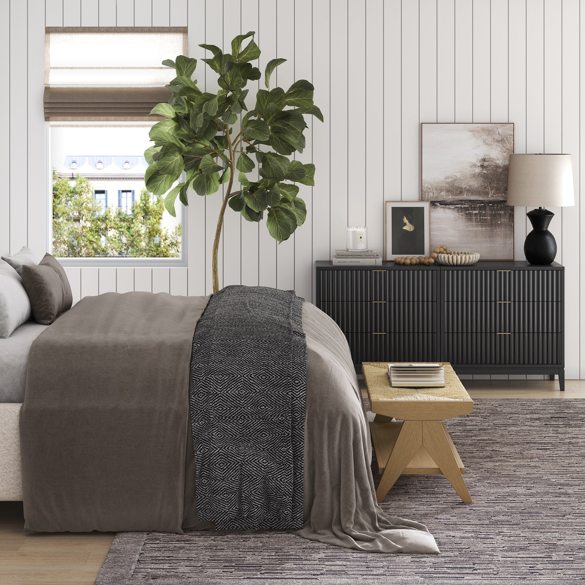 A modern bedroom with a neatly made bed, patterned blanket, potted plant by the window, wooden bench, and the Nathan James Mid-Century Fluted 3-Drawer Dresser in Black. Neutral-colored walls are accented with elegant white paneling.