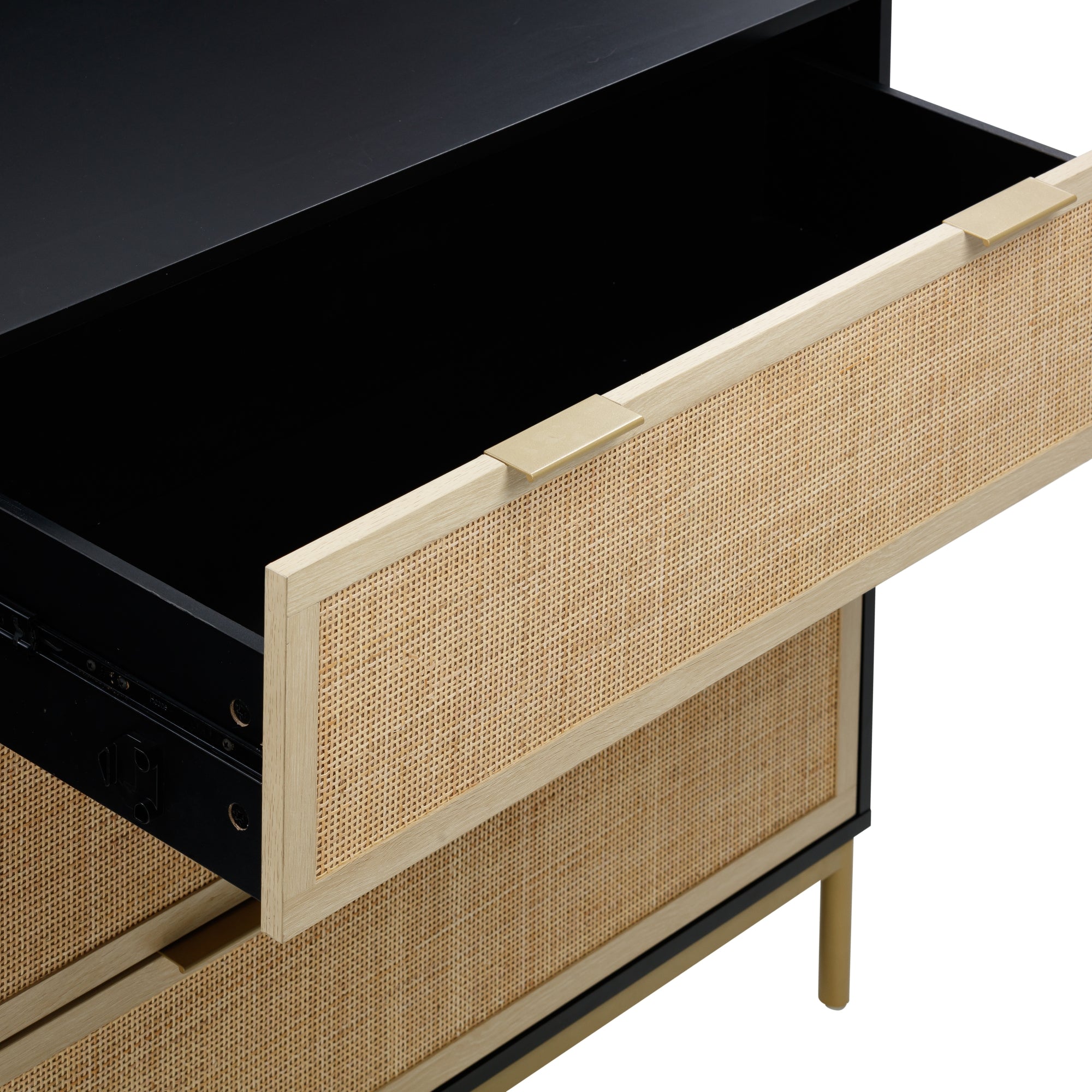 A close-up of a dresser with a partially open drawer, featuring a light wood frame and woven rattan front panel, revealing a spacious and empty black interior.